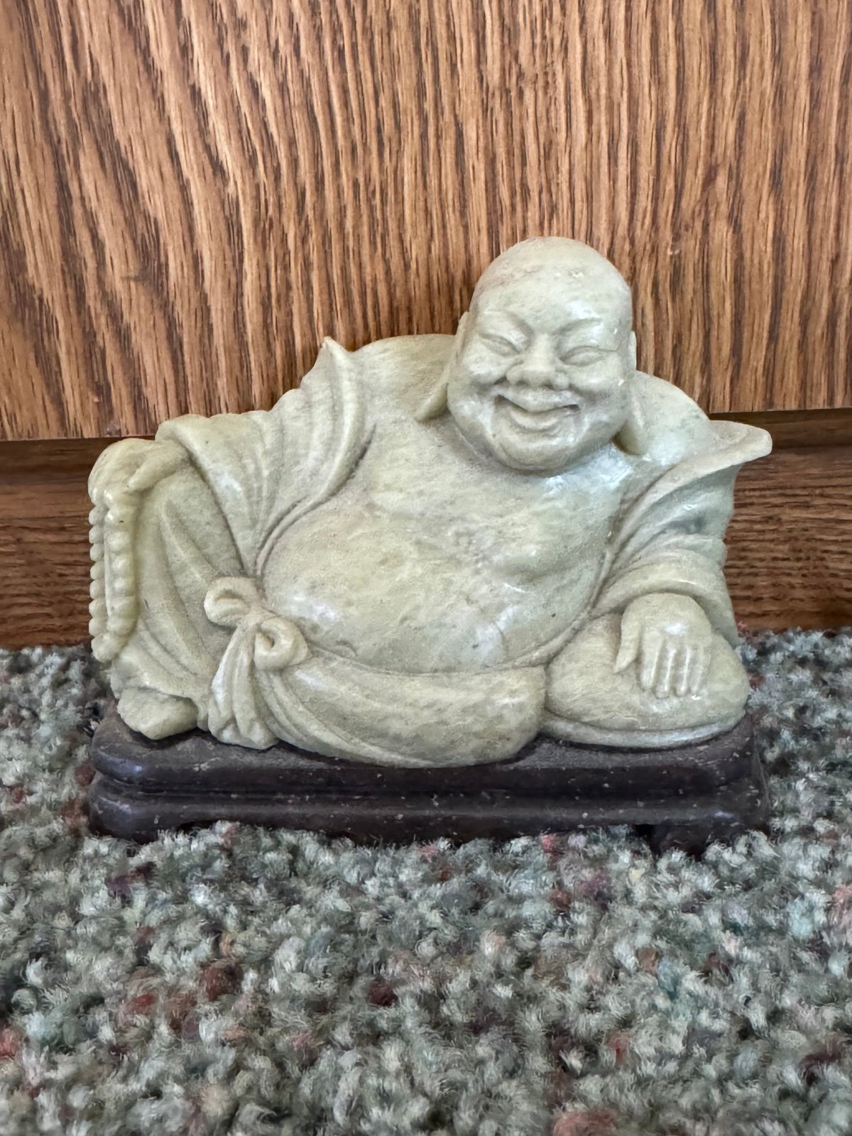 Laughing Buddha Celedon Stone on a wood stand