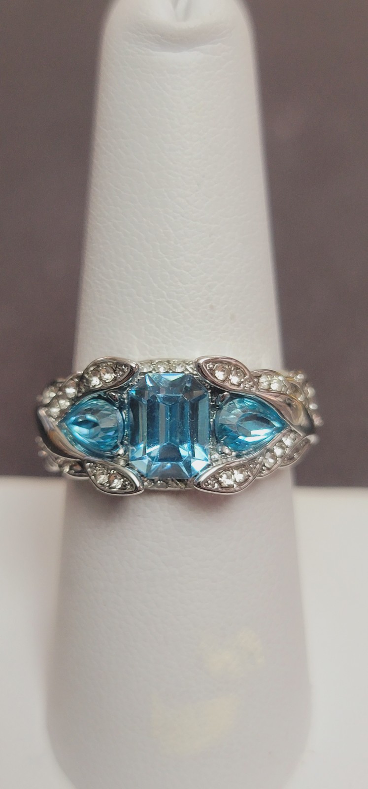 R609 Sky Blue Zircon 3 Stone Cocktail ring.Size 7.5. Rhodium plated 9x7mm em