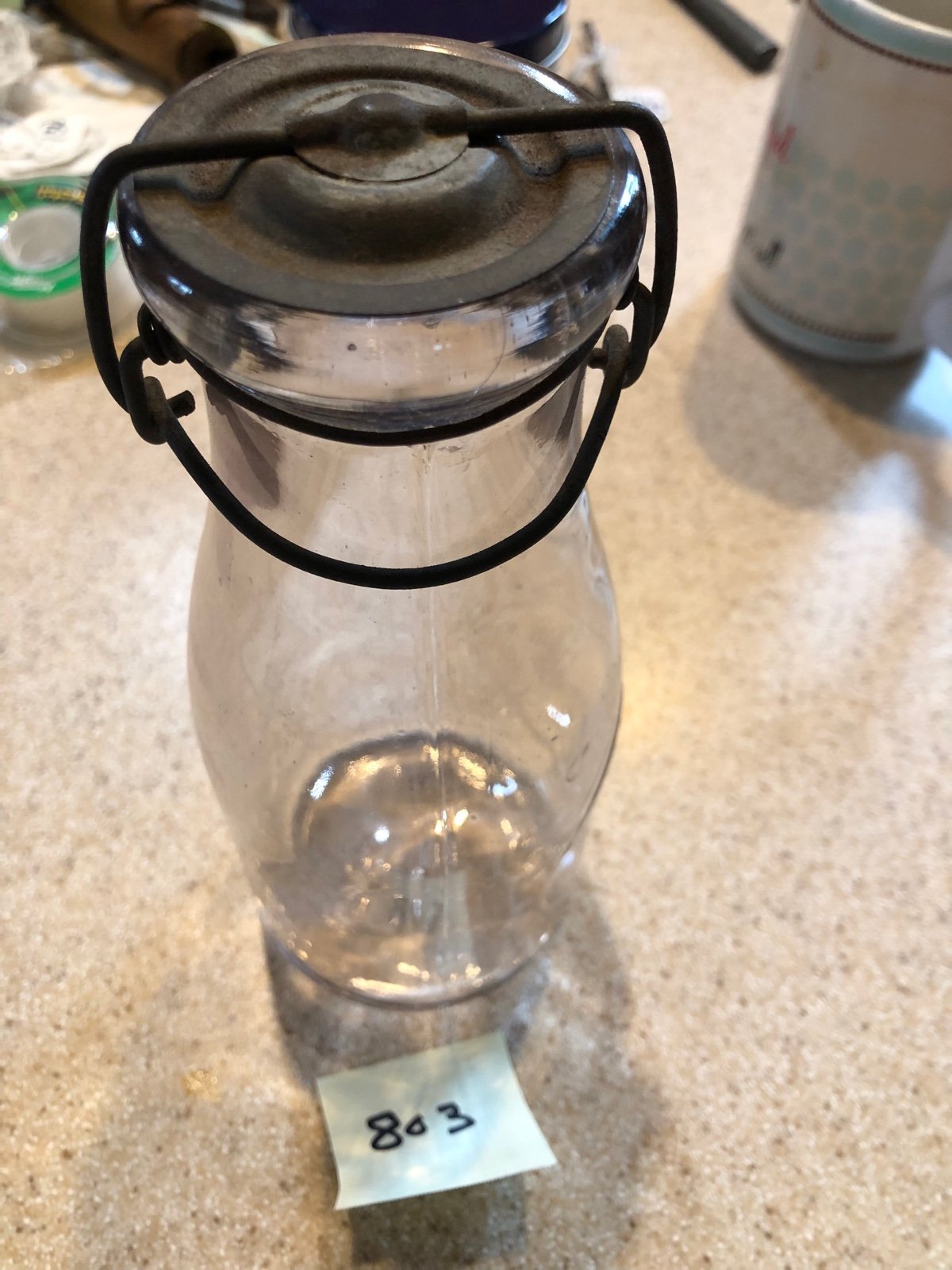 Glass pint milk bottle with tin lid