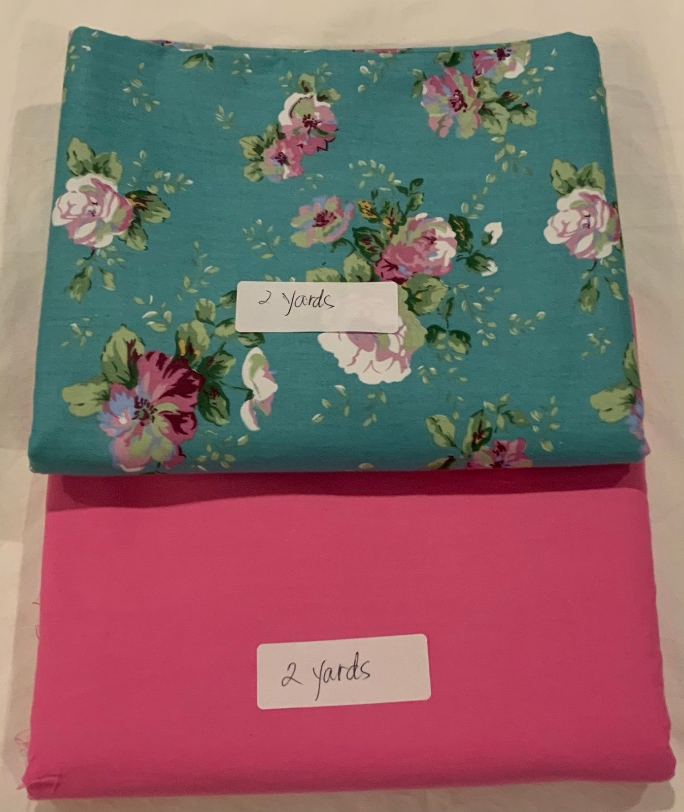 Fabric in teal floral and pink solid . Will receive 2 yards each