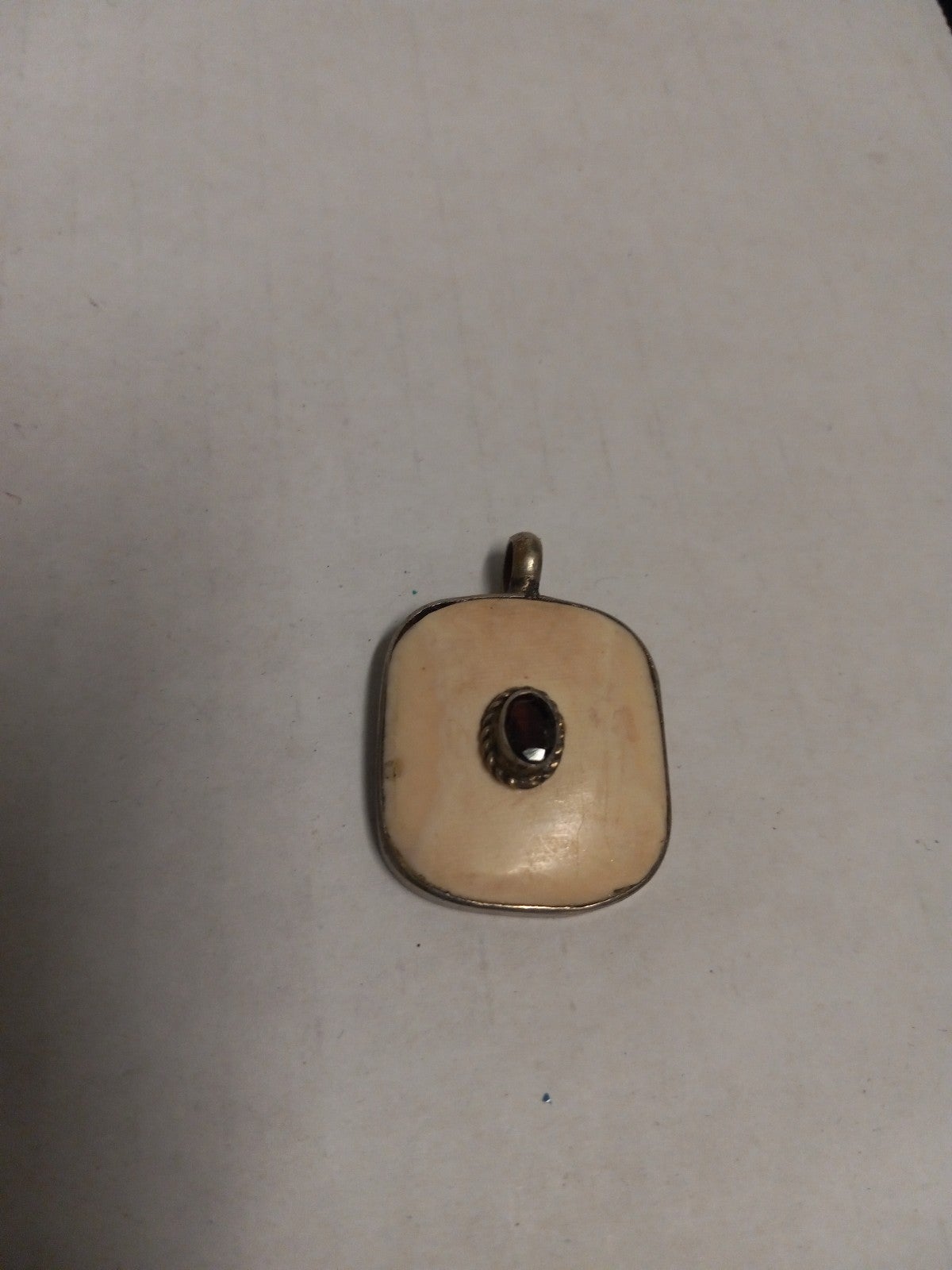 Hand carved bone pendant with Ruby