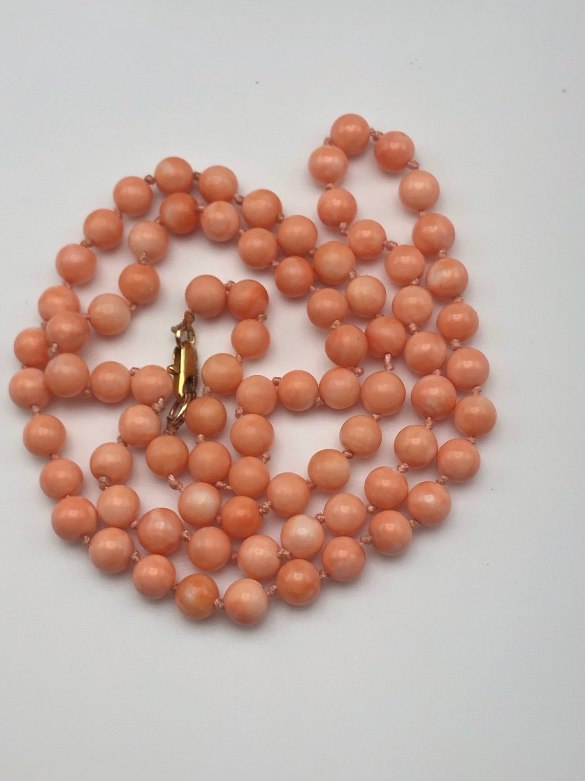 Beautiful hand knotted string of coral angelskin salmon pink beads with gold