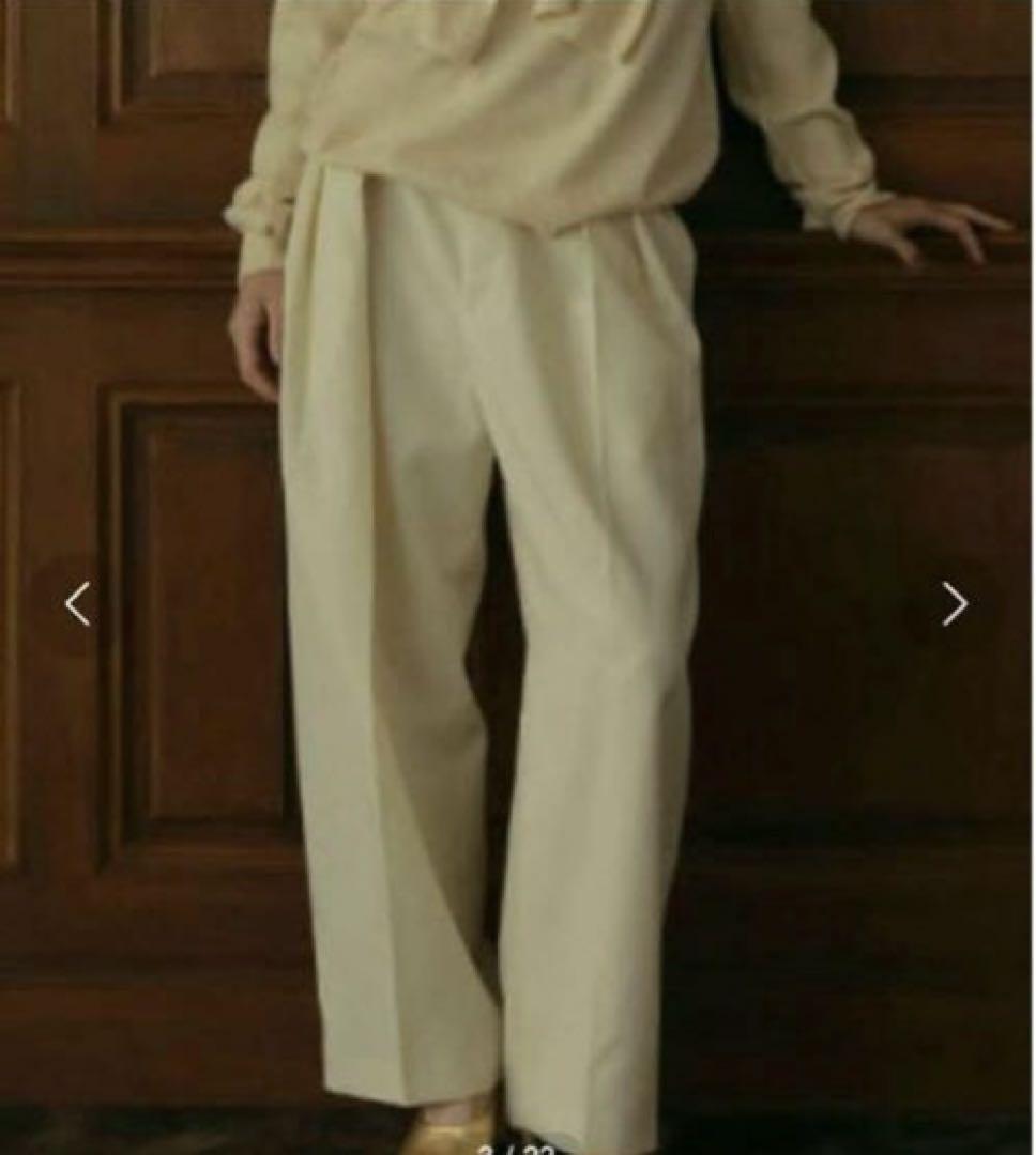 Cream-colored wide pants with pleats design.