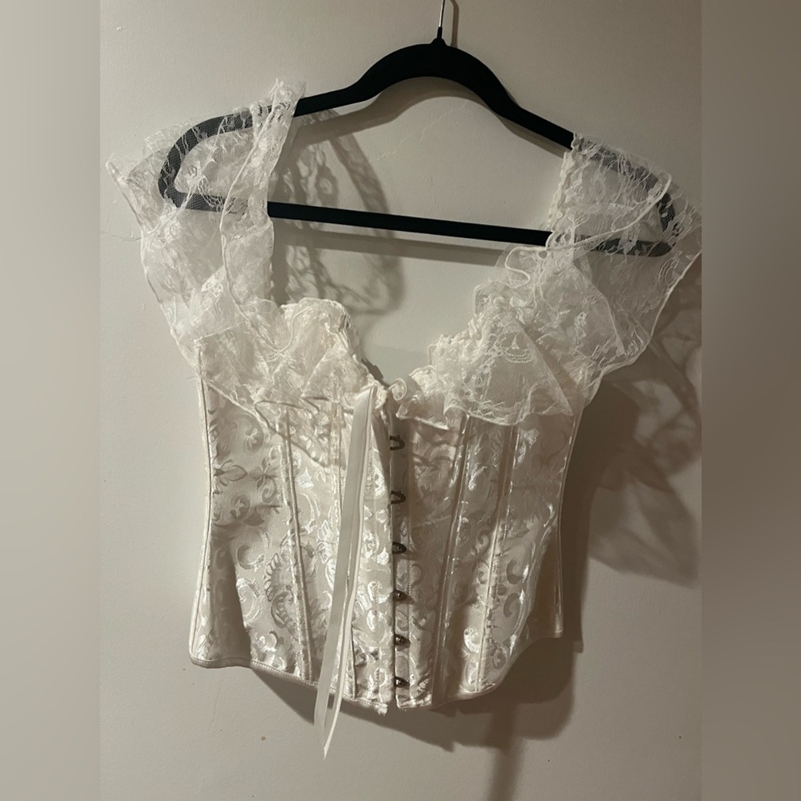 White lace corset. Corset has draped lace shoulder with tie back