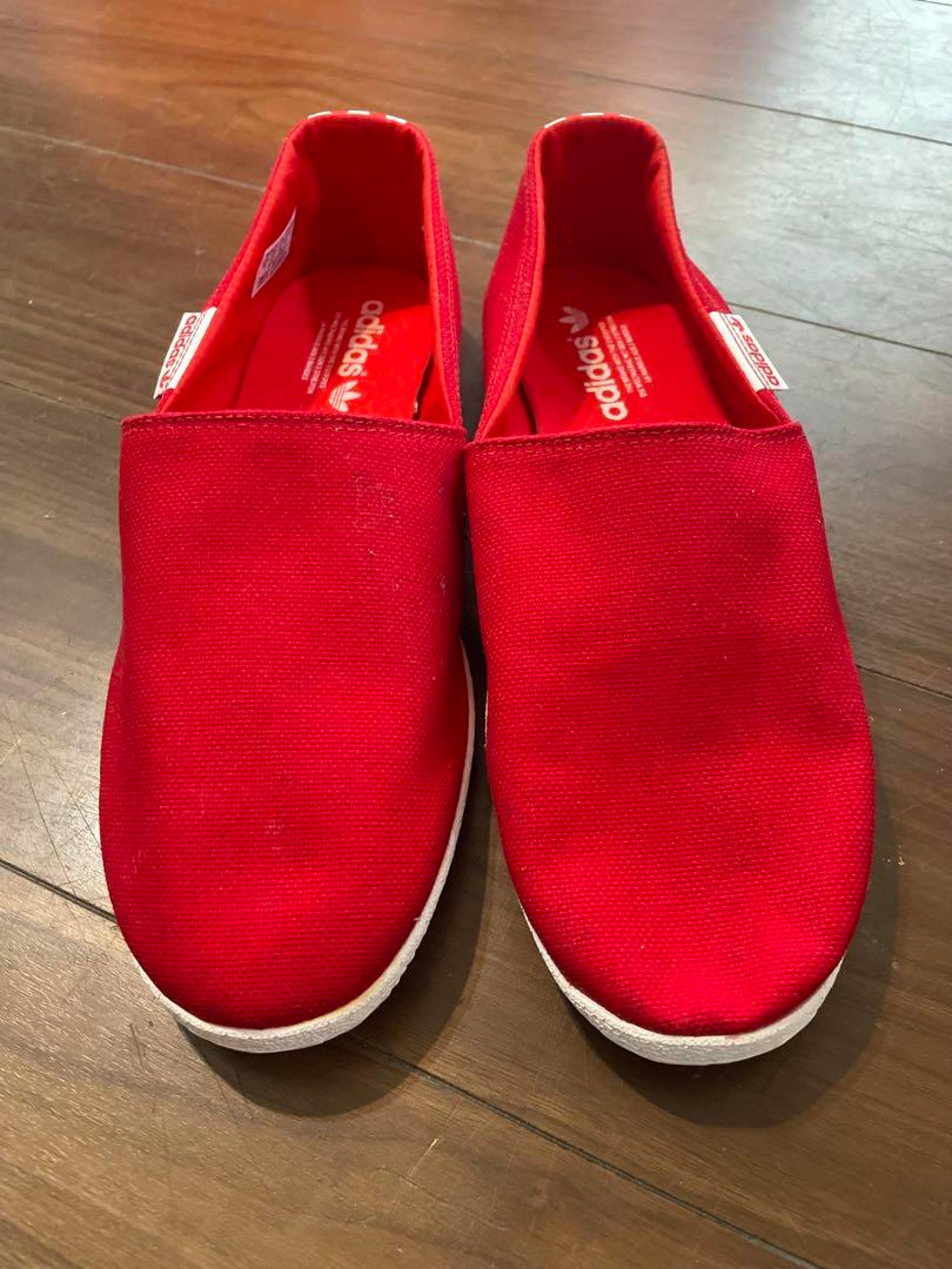 adidas red slip-on with three stripes design