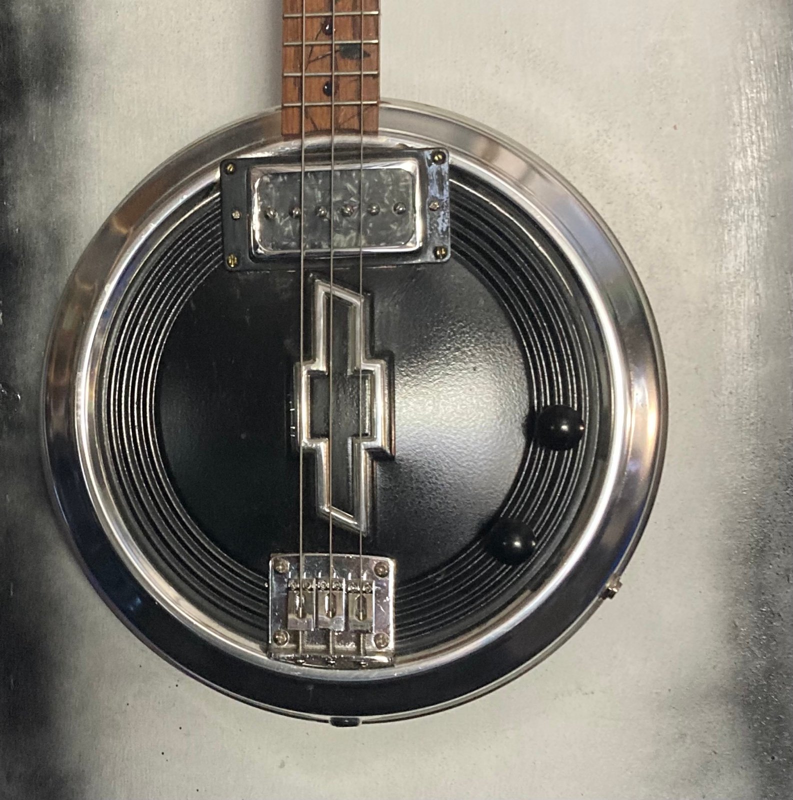 3 string electric Chevy hubcap guitar