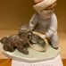 Figurine of young boy playing with his dog and a hoop