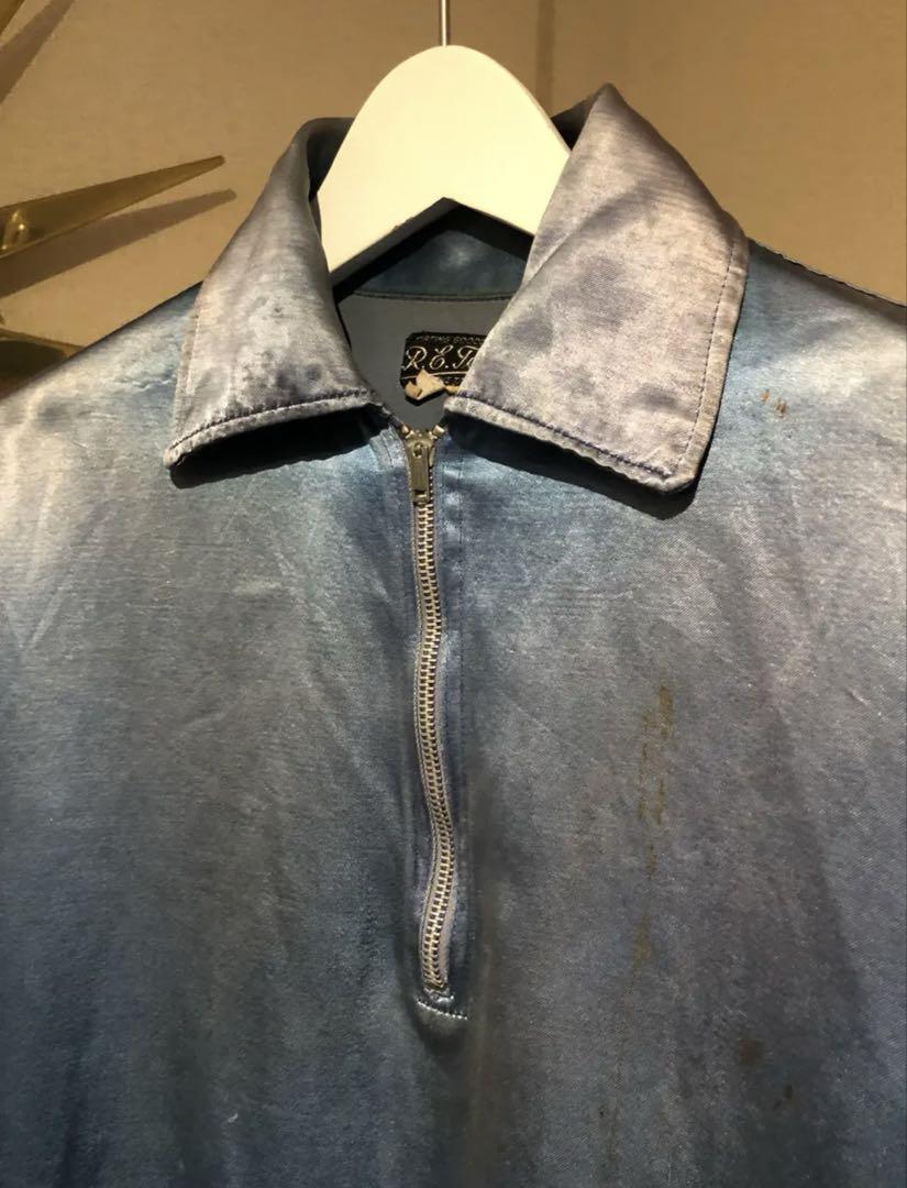 A half-zip blue satin jacket from the 1950s. Varsity/baseball