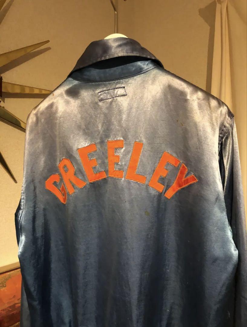 A half-zip blue satin jacket from the 1950s. Varsity/baseball
