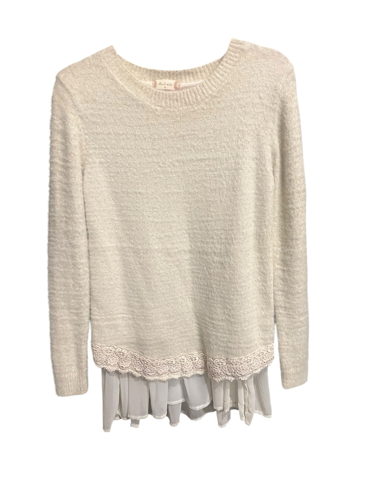 cream sweater featuring a delicate lace ruffle hem.