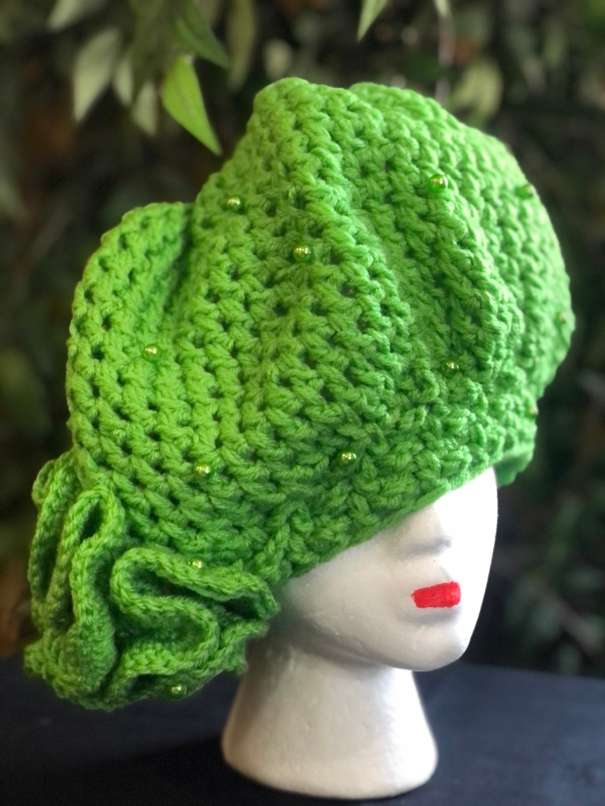 Hand made, apple green crocheted hat, convered with apple green pearls with a fl