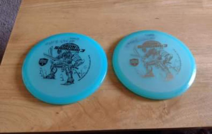 A pair of discmania eagle McMahon glow iron samurai 3