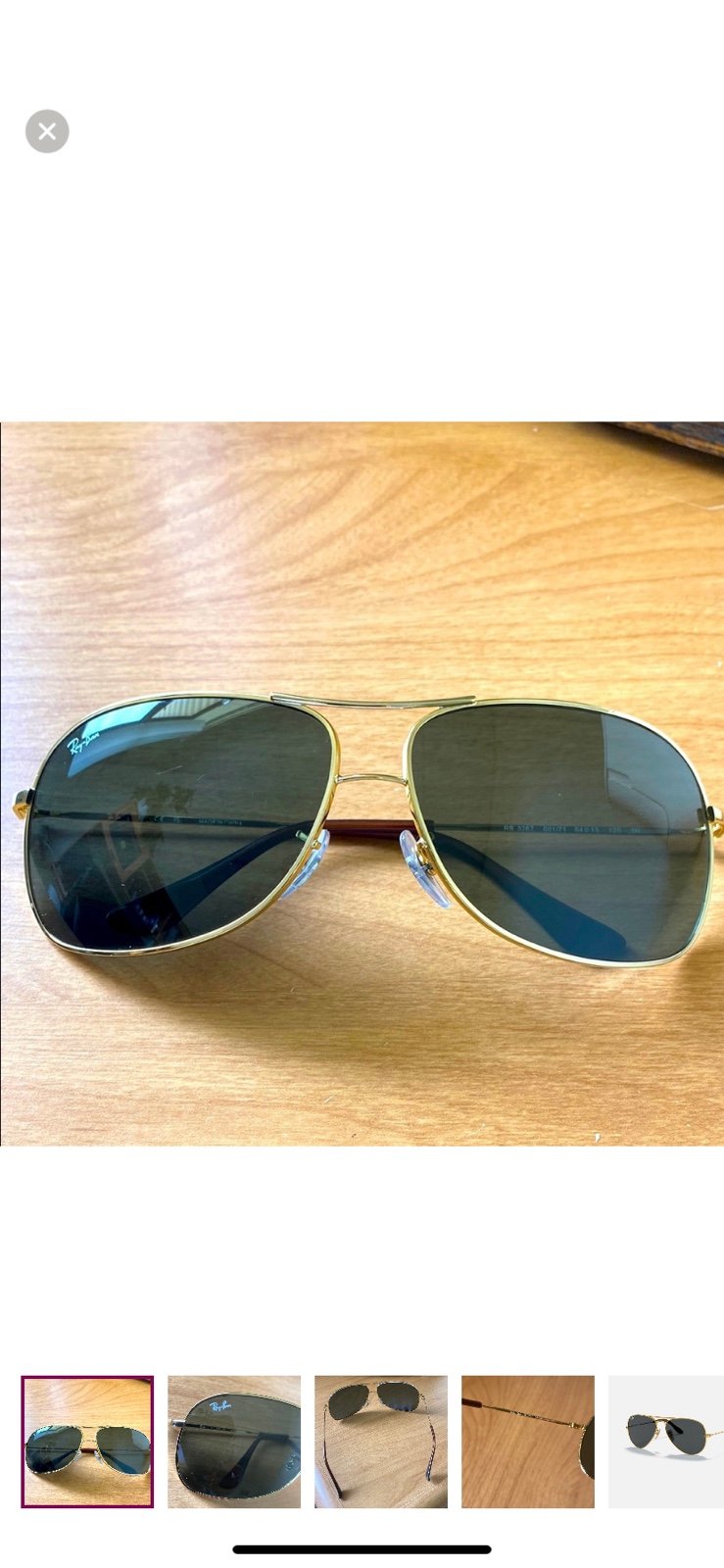 Ray-Ban aviator sunglasses with gold frames and dark grey lenses.
