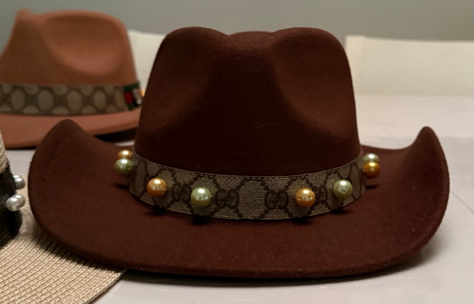 Felt cowboy hat with material band with pearl accents.