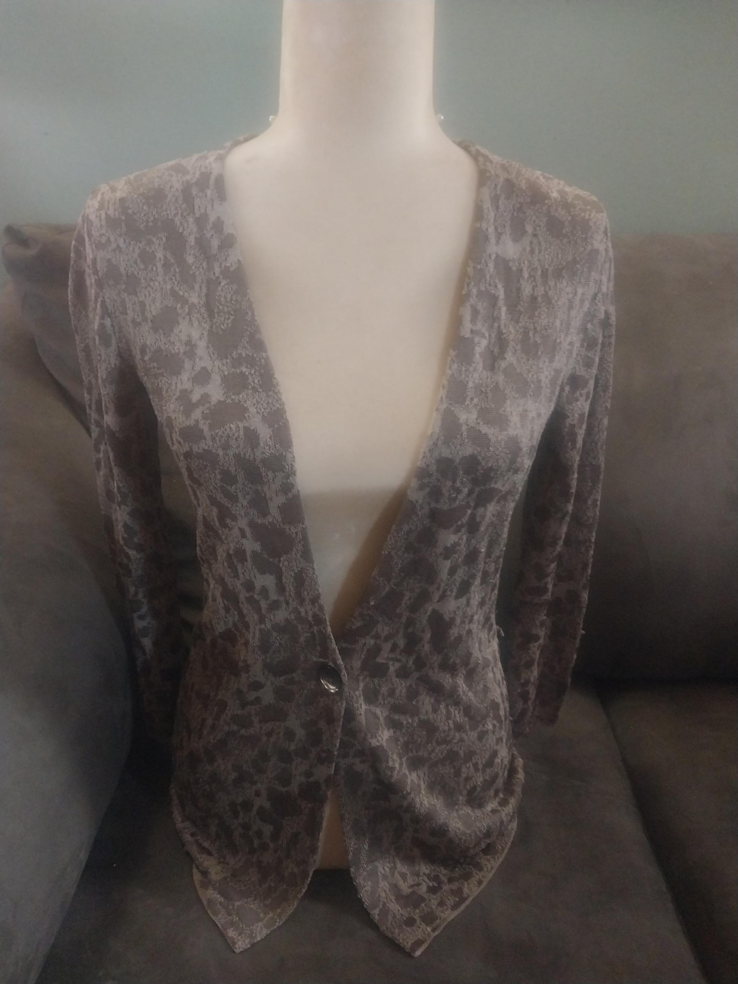 Silky rayon/nylon knit single button, animal print cardigan.  Flattering fit.