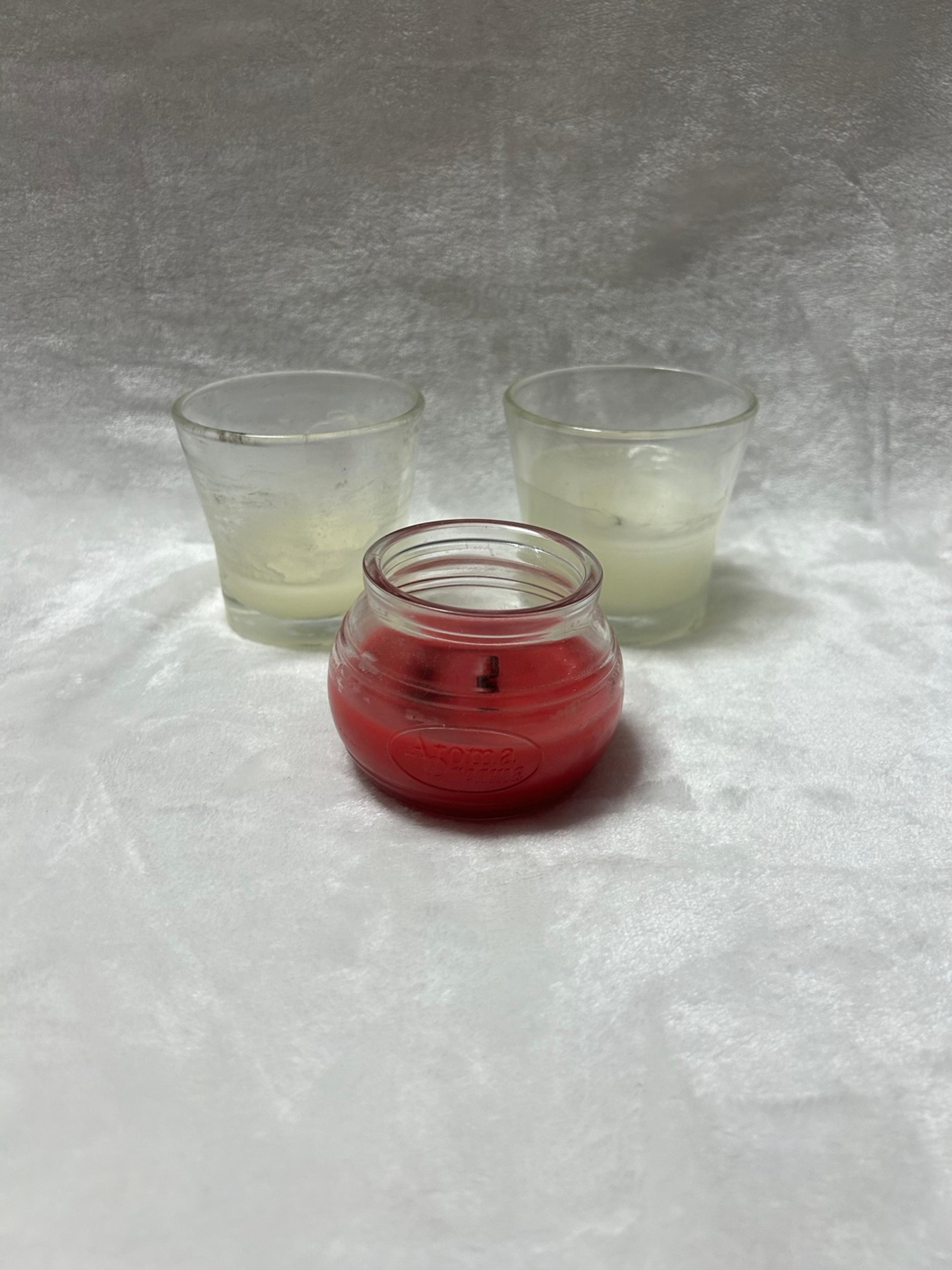 Two Glade scented white candles one red candle in glass jars