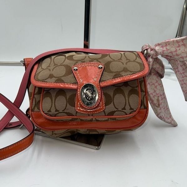 Coach Legacy Signature Canvas Crossbody Bag with a turn-lock closure.