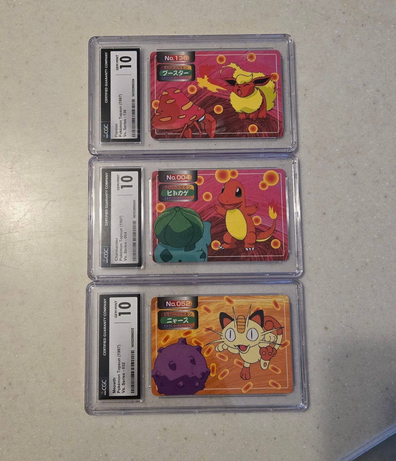 Ultra RARE Pokemon card set graded 10 1997 052 004 and 136 Charmander meowth