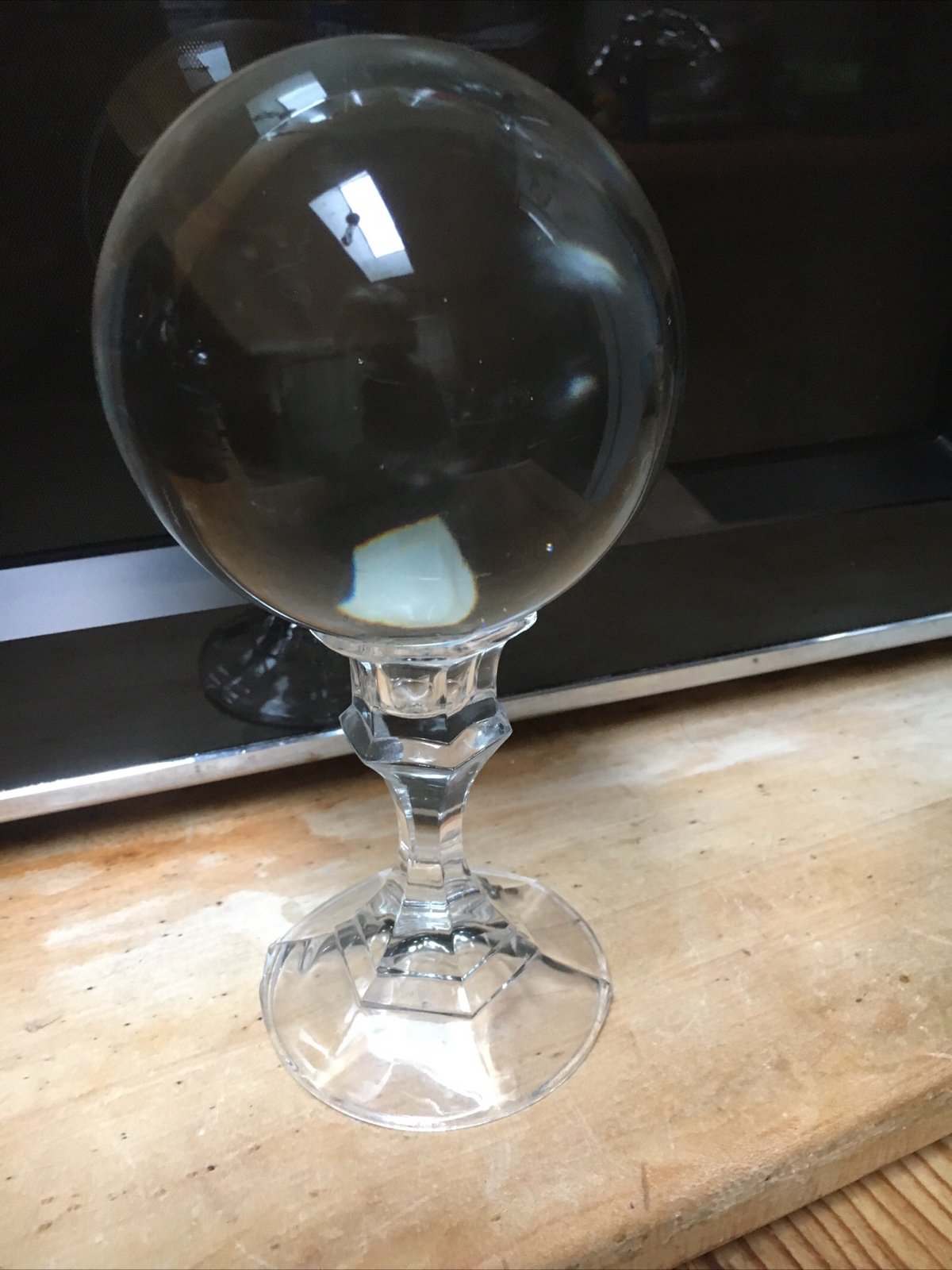Crystal gazing ball on clear glass pedestal