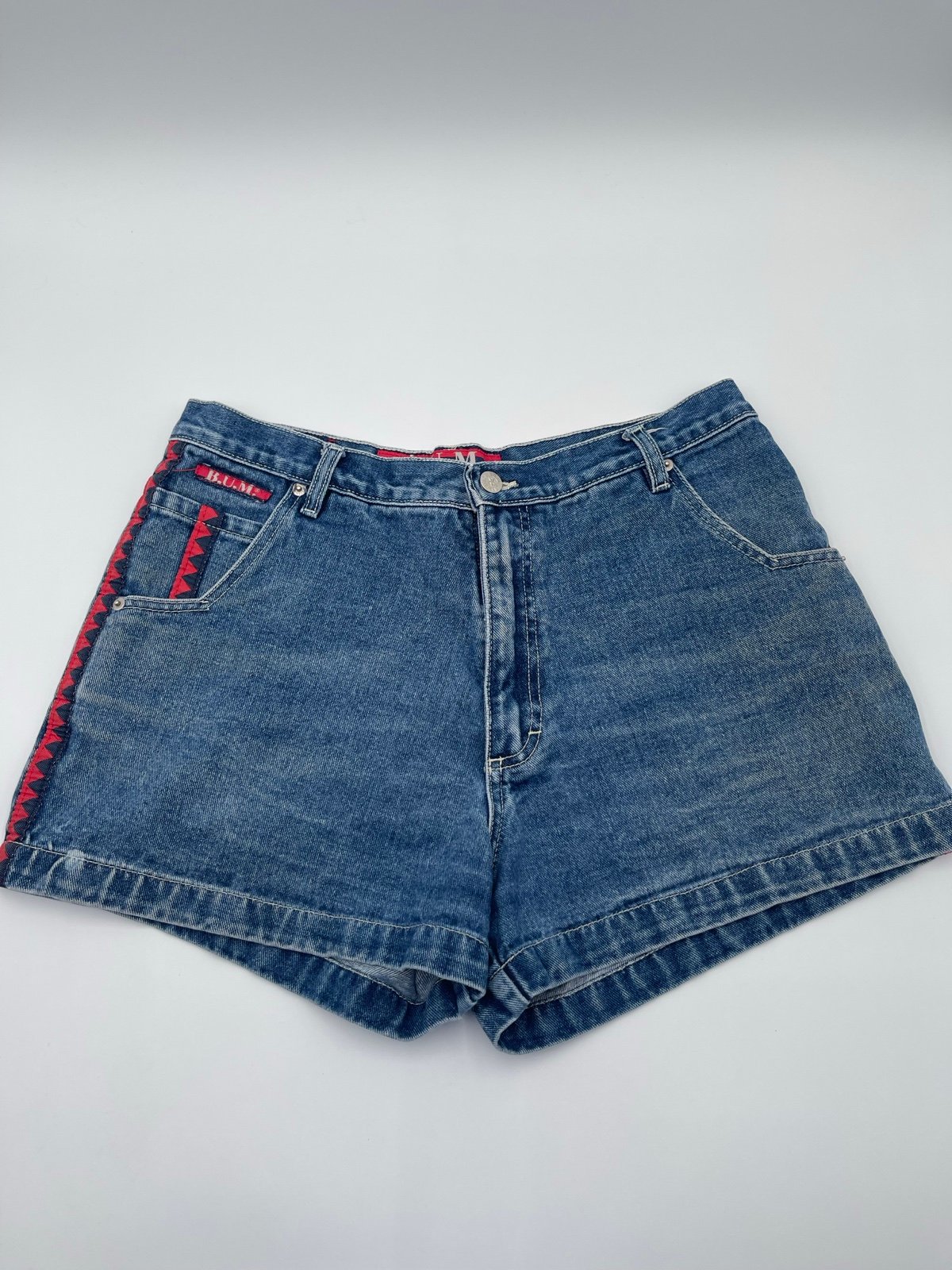 Vintage B.U.M Equipment blue denim shorts with red accents. Women’s size 13/14