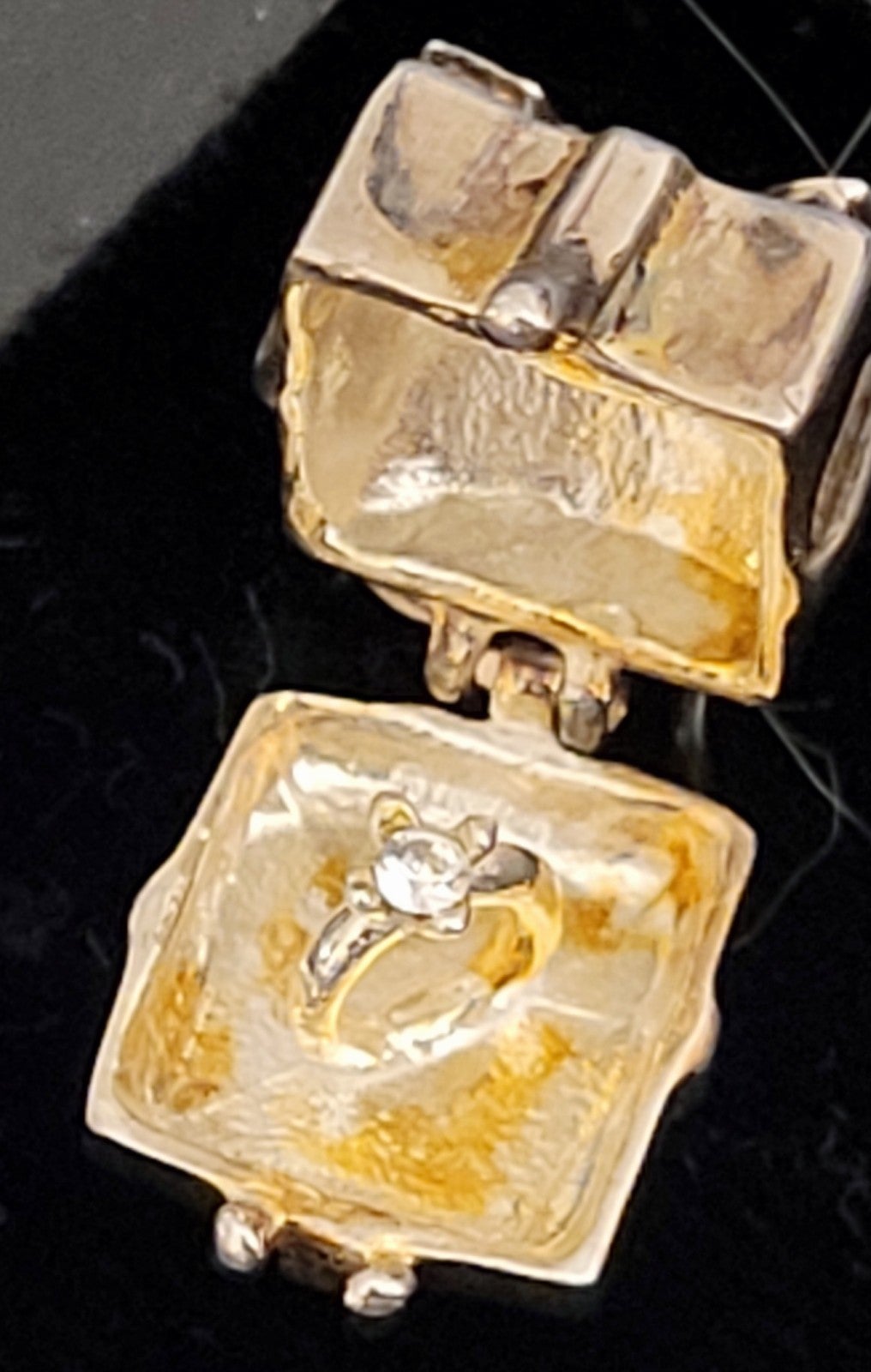 BN RING BOX CHARM WITH AN ENGAGEMENT RING INSIDE.