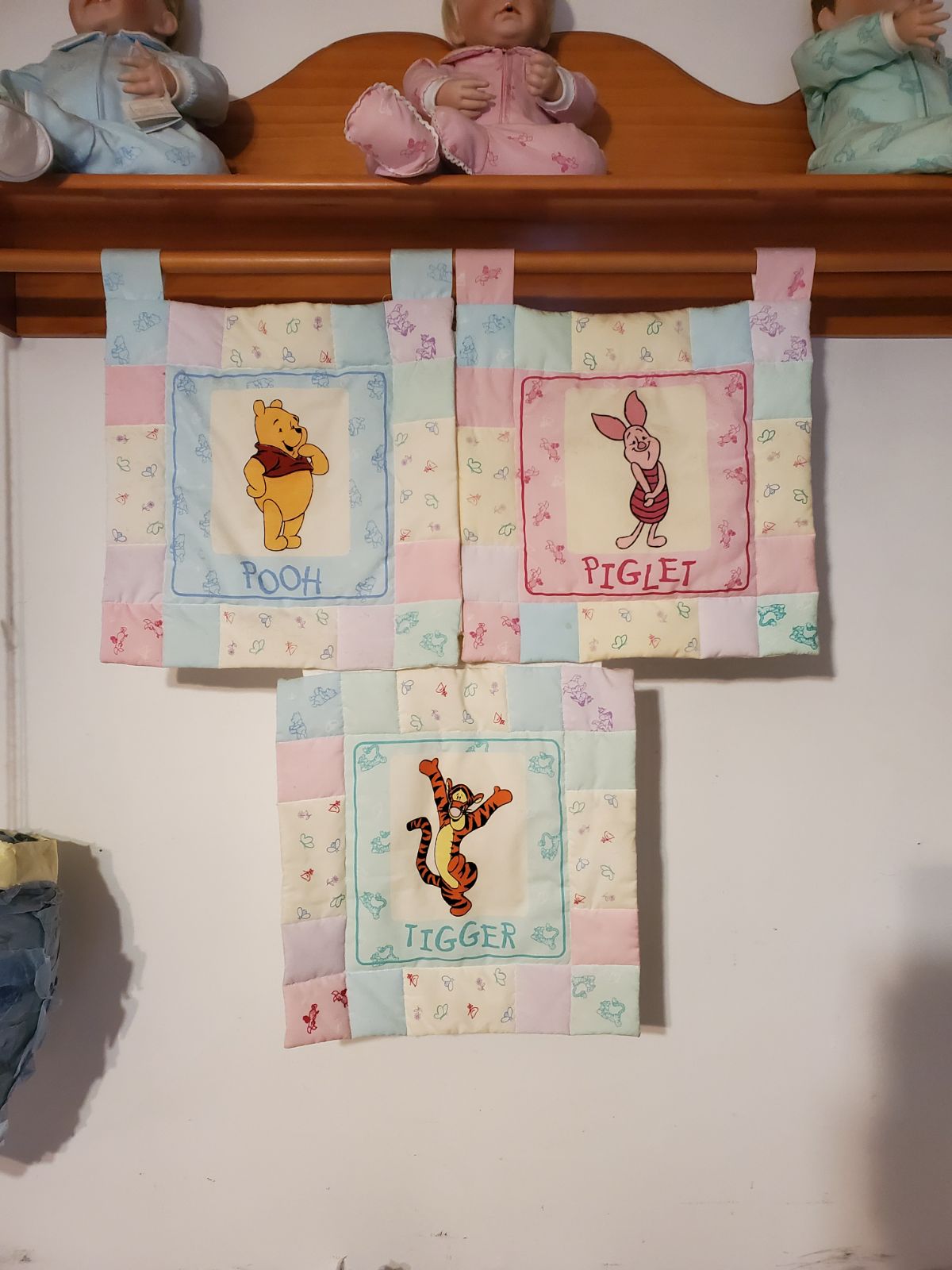 2 winnie the pooh porcelain dolls. Plus quilted blanket and wooden shelf.