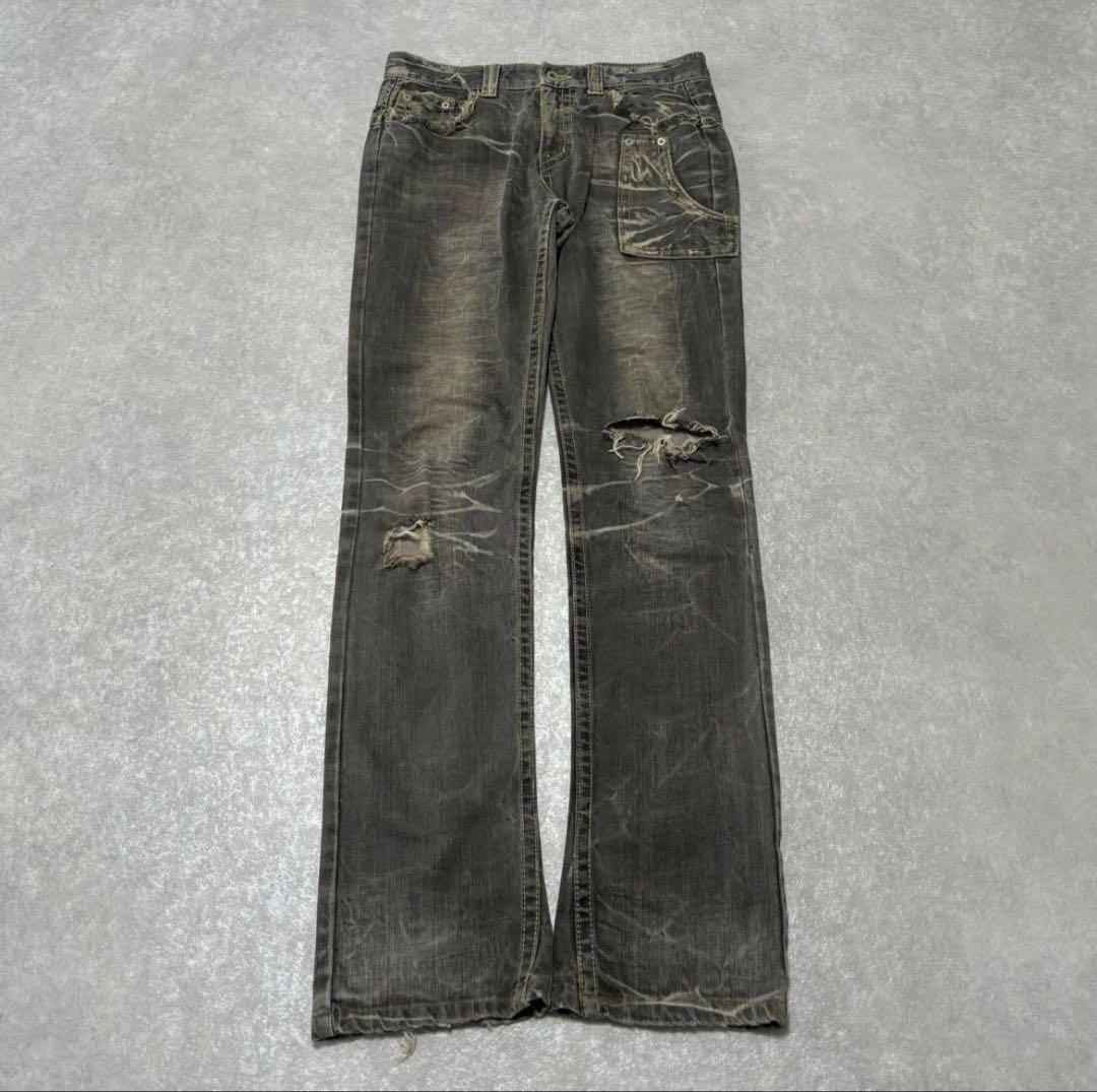 Black denim pants with grunge damage in a Y2K style.
