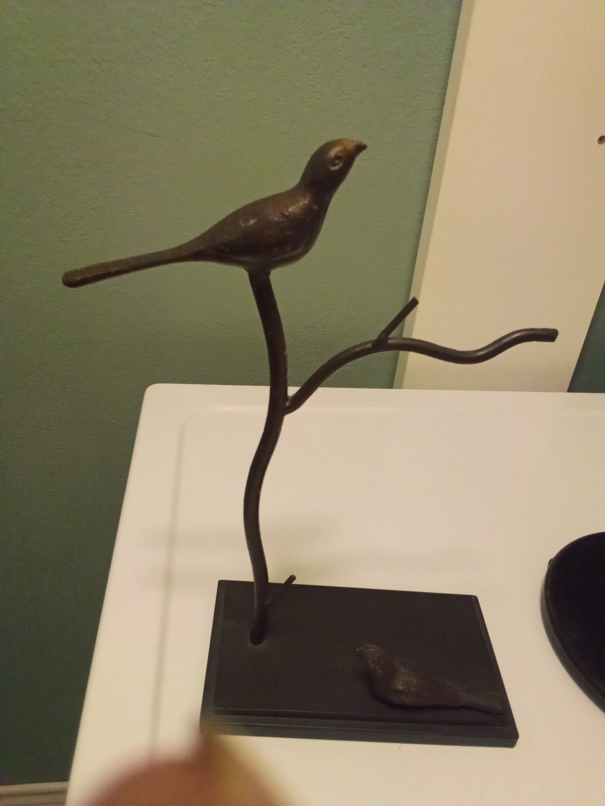 Metal bird sculpture on base