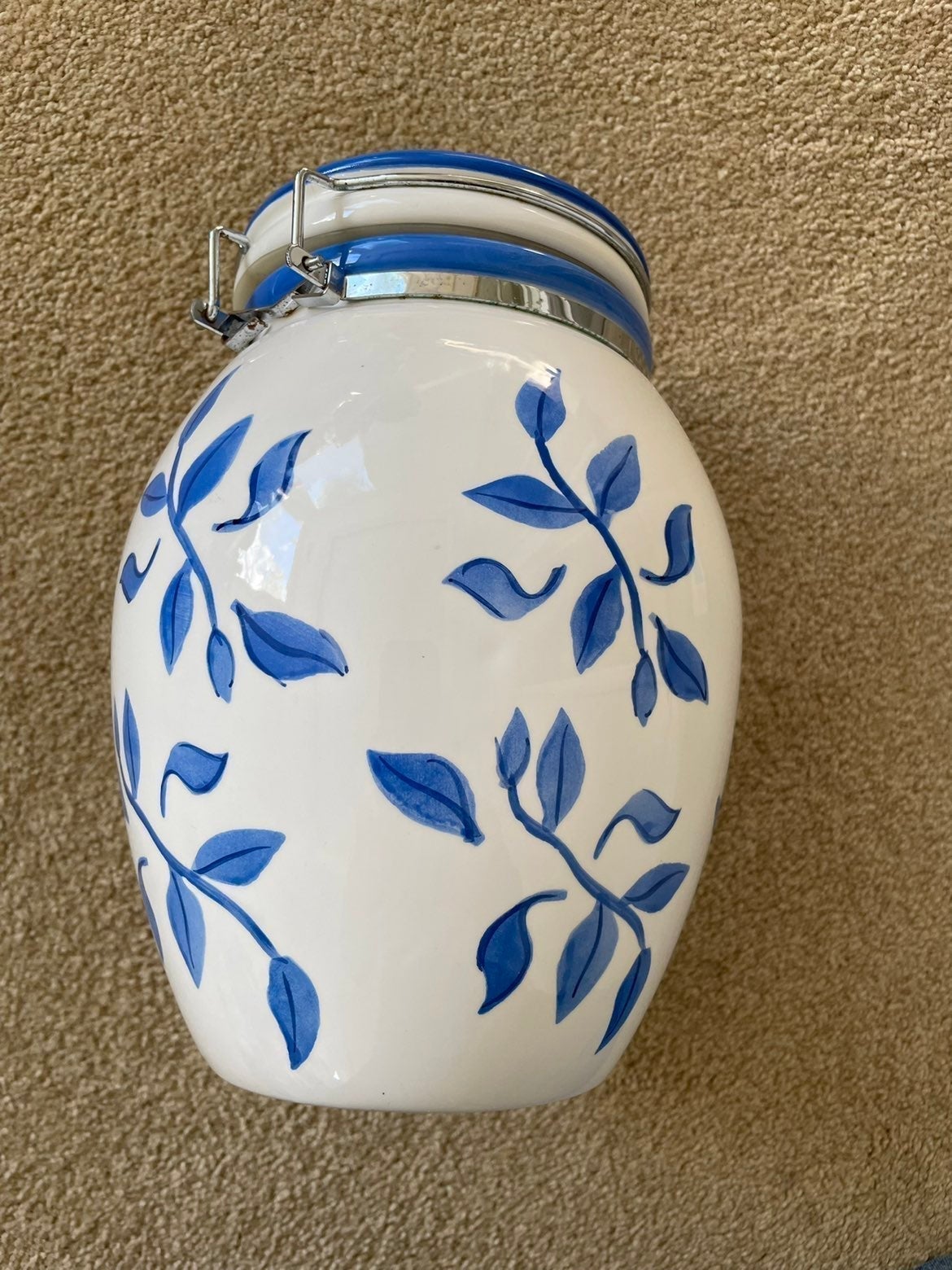 This is an Inspidaro ceramic canister with blue leaves design on white backgroun