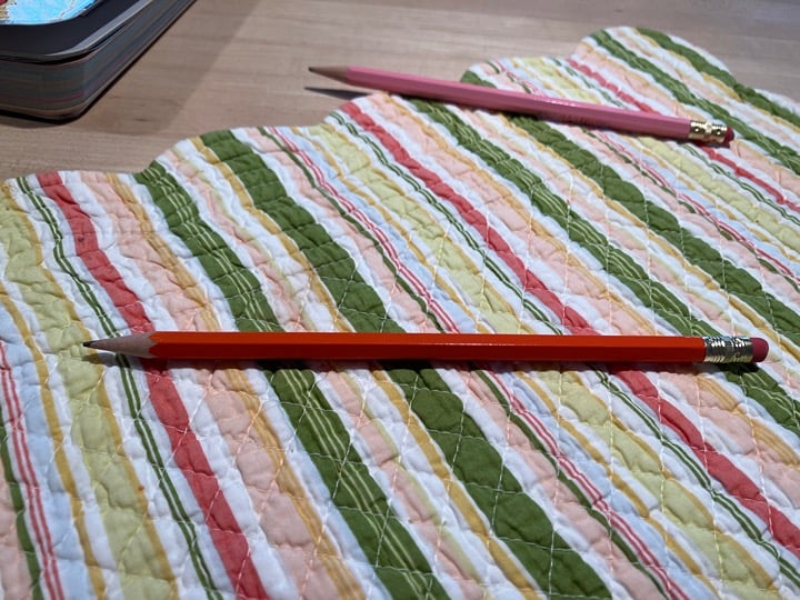 Orange pencil that has the word scribbles on the side
