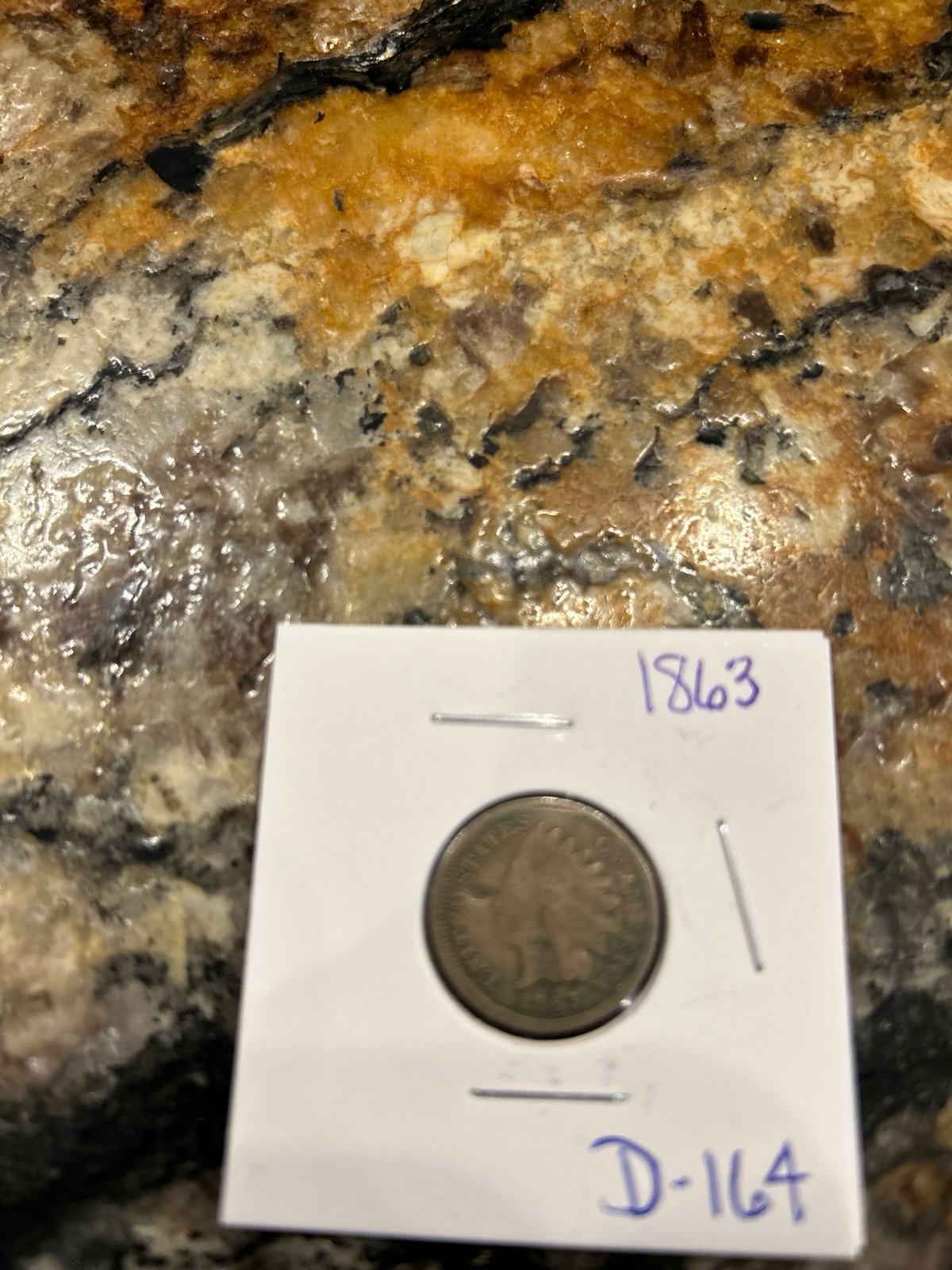 1863 Indian head cent with pointed bust wearing Indian headdress .