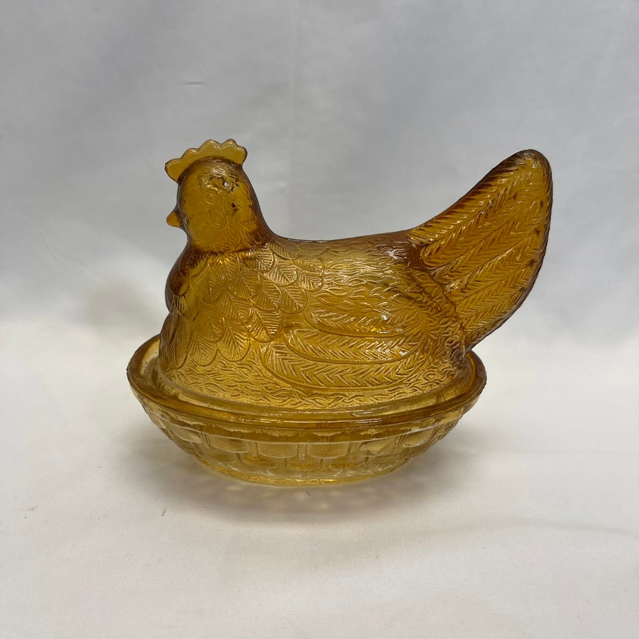 Vintage hen on nest amber