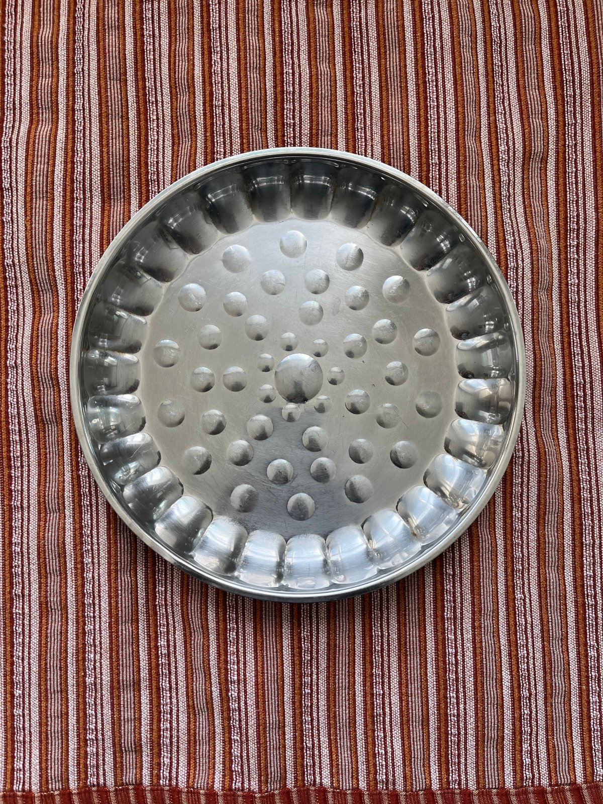 Two large stainless steel plates / raised edges so half bowl like