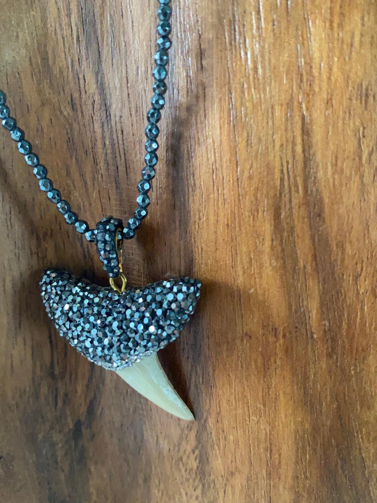 Shark tooh necklace adorned with hematite