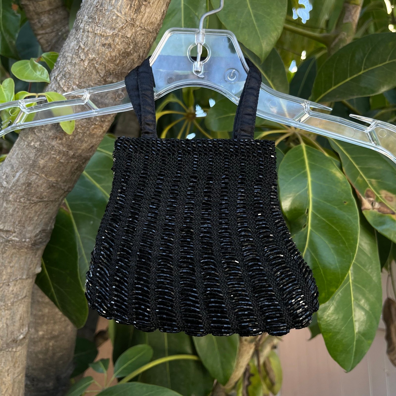 Black mini bag featuring intricate beaded detailing. I