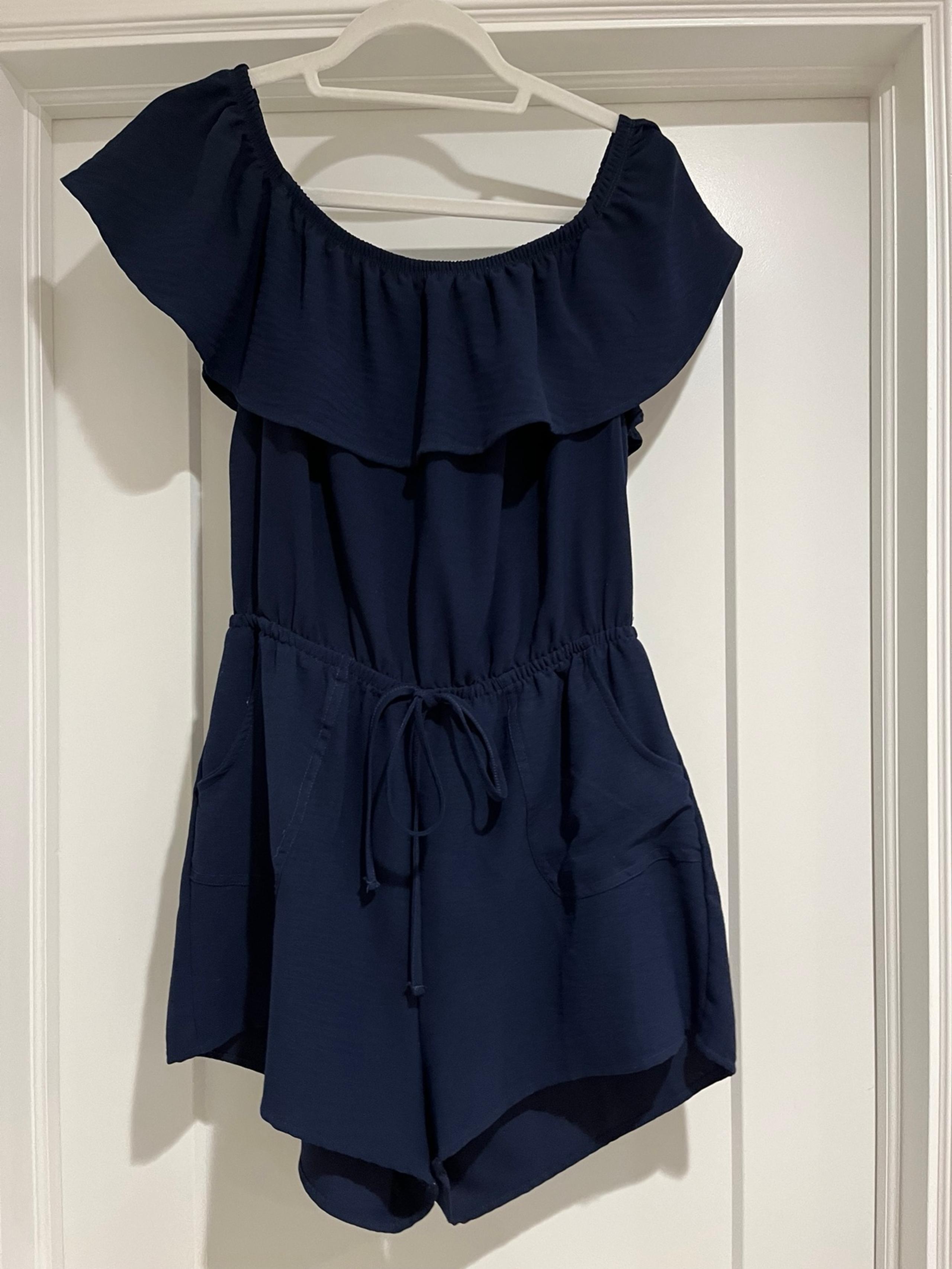 Iris navy blue short romper. Ties in the middle. Ruffle top. Size large.
