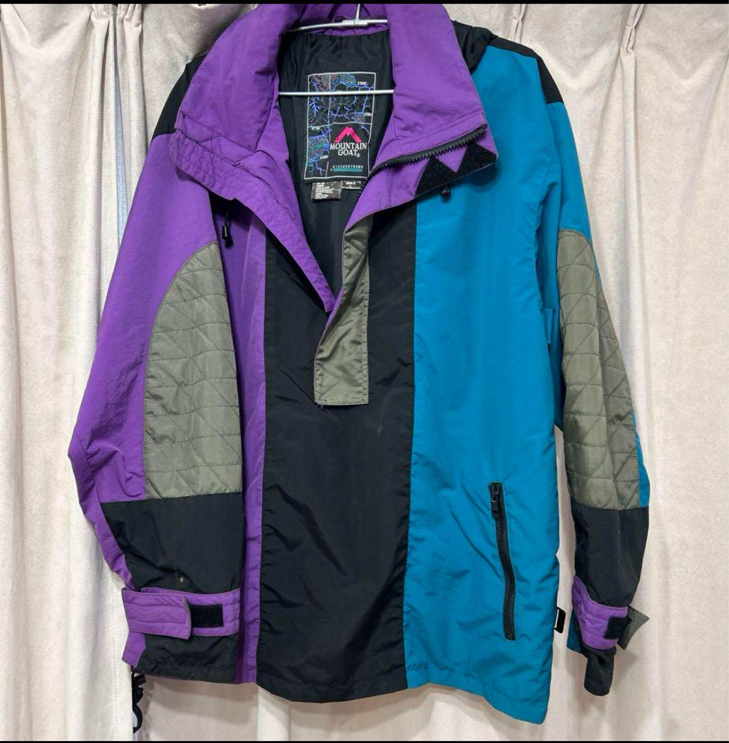 Mountain parka in purple, blue, black, and green.