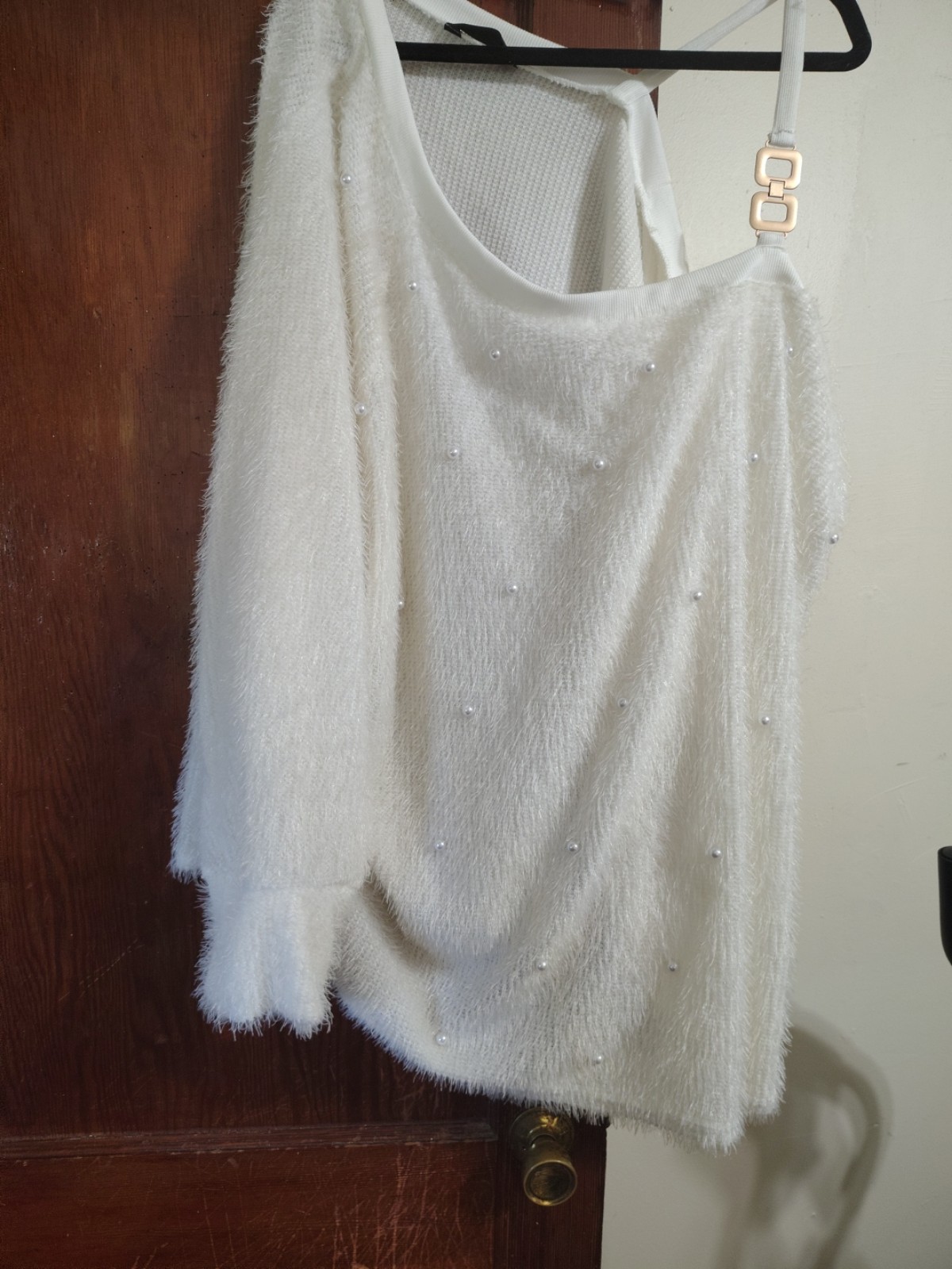 White sweater with pearls.