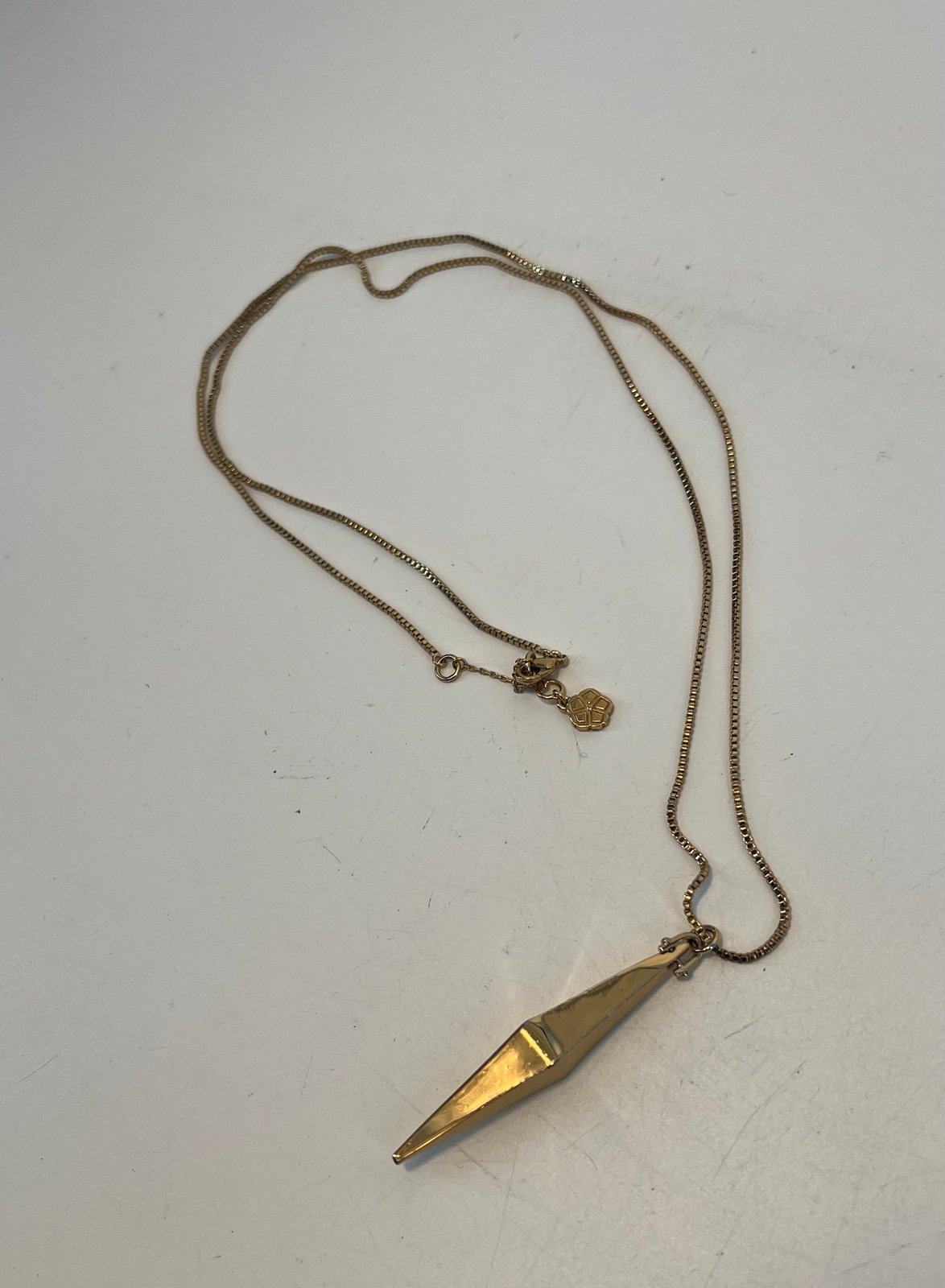 Trina Turk long gold necklace with elongated diamond shaped pendant on chain