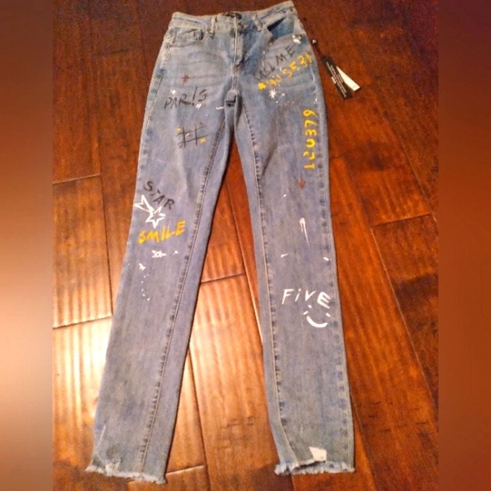 Trendy Distressed Light Wash Denim Jeans with Custom Graffiti Art and Raw Hem