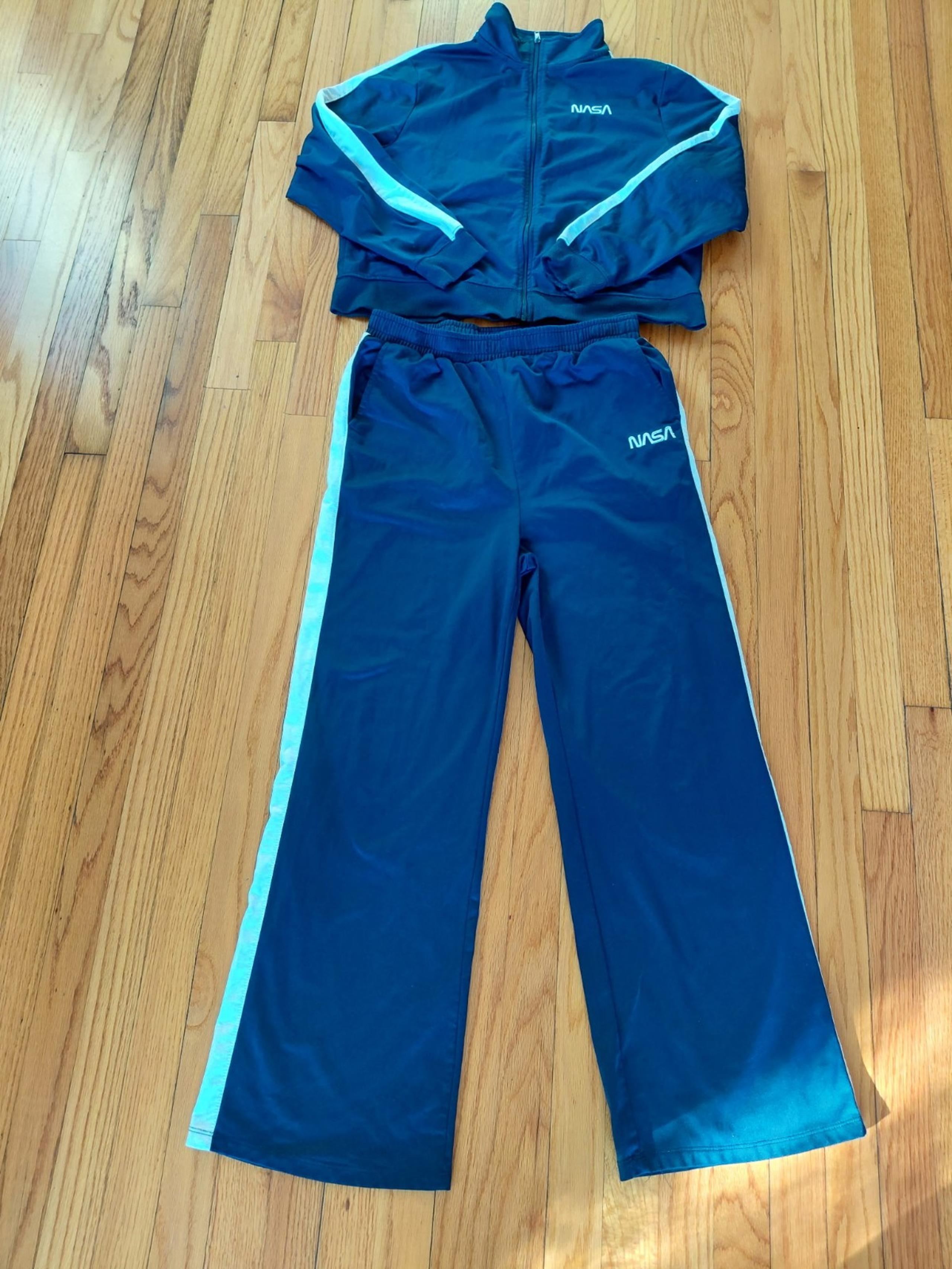Stylish blue tracksuit featuring white stripes and NASA logo.