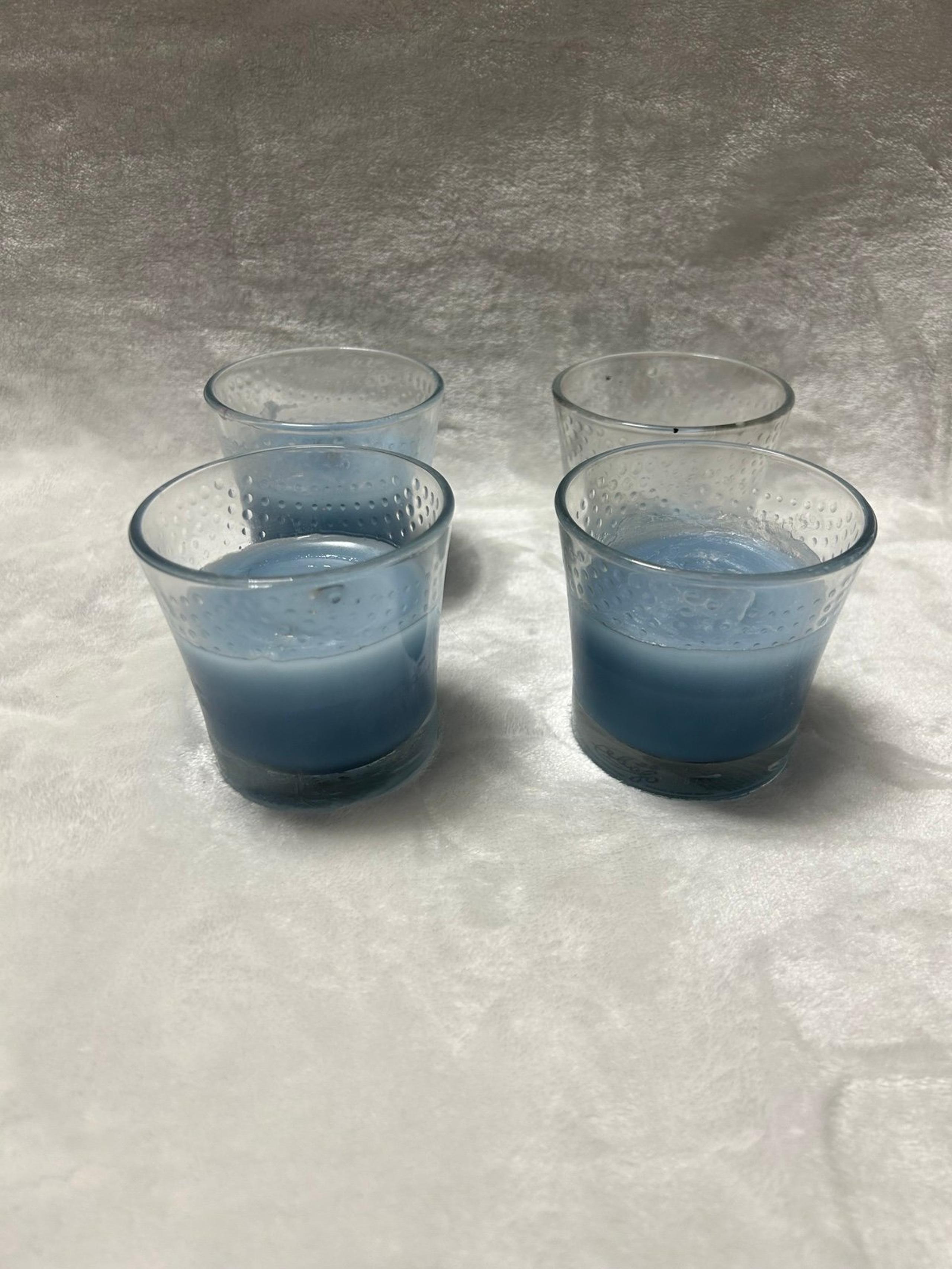 Four blue Glade Scented Candles in glass jar