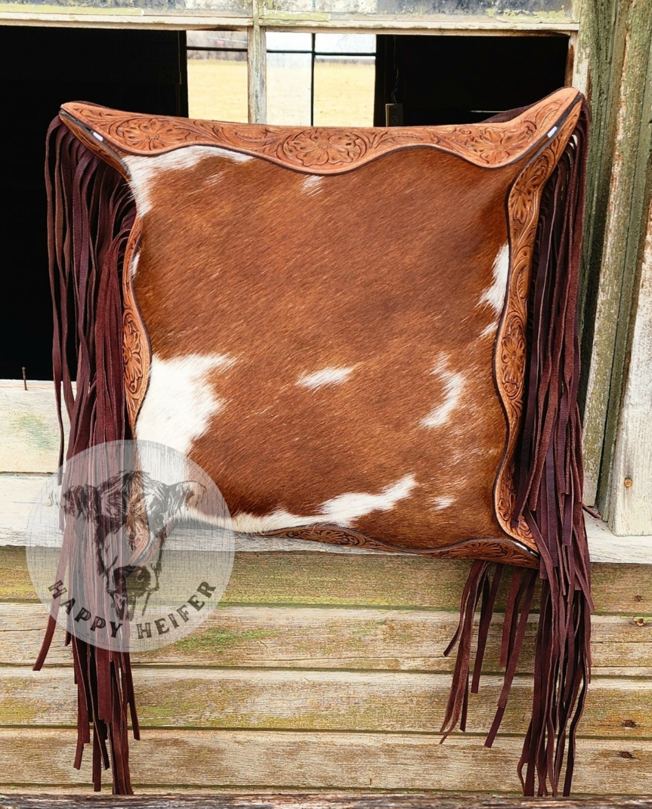 Stylish cowhide pillow with intricate leather trim. NWT