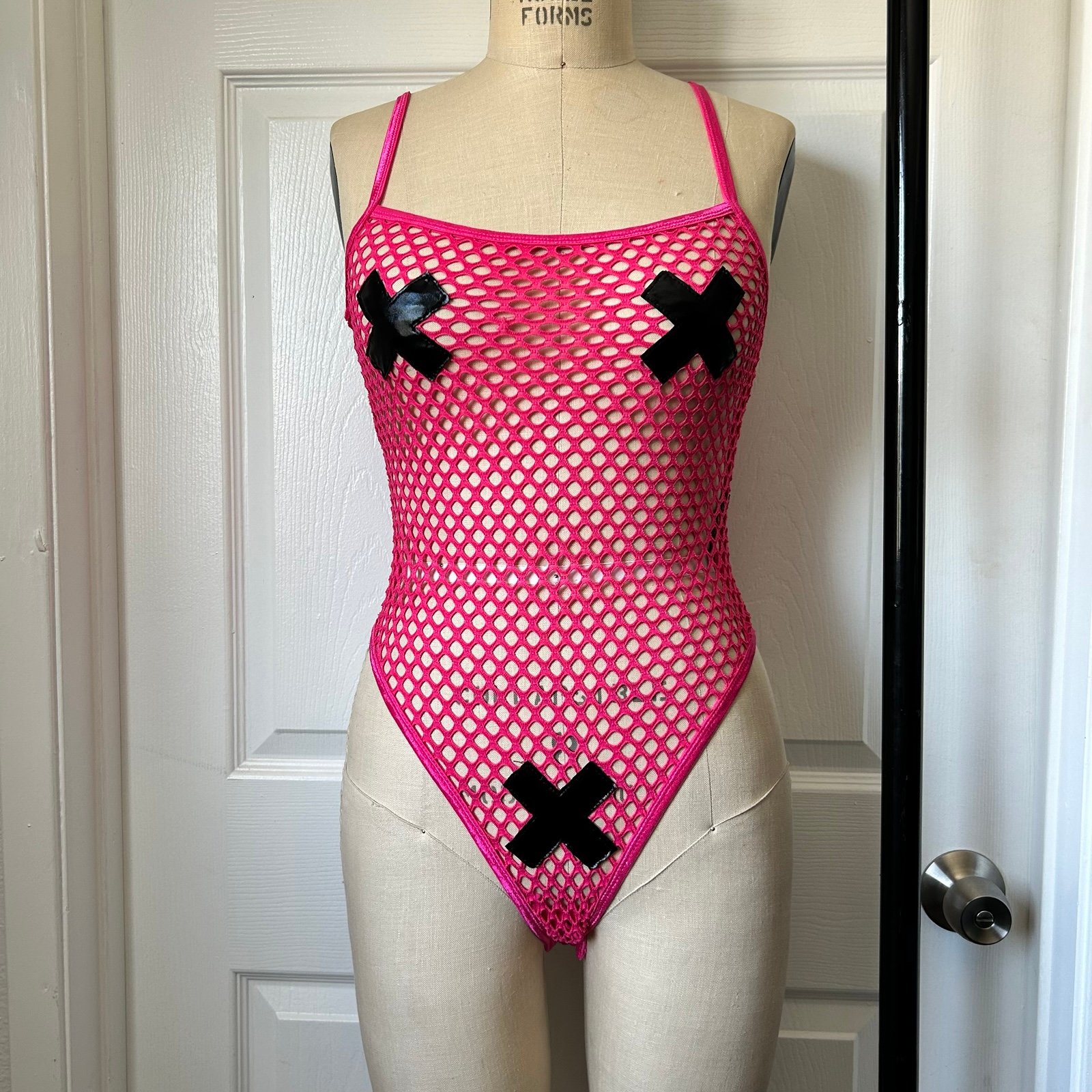 Club exx Pink fishnet bodysuit with black crosses and adjustable straps