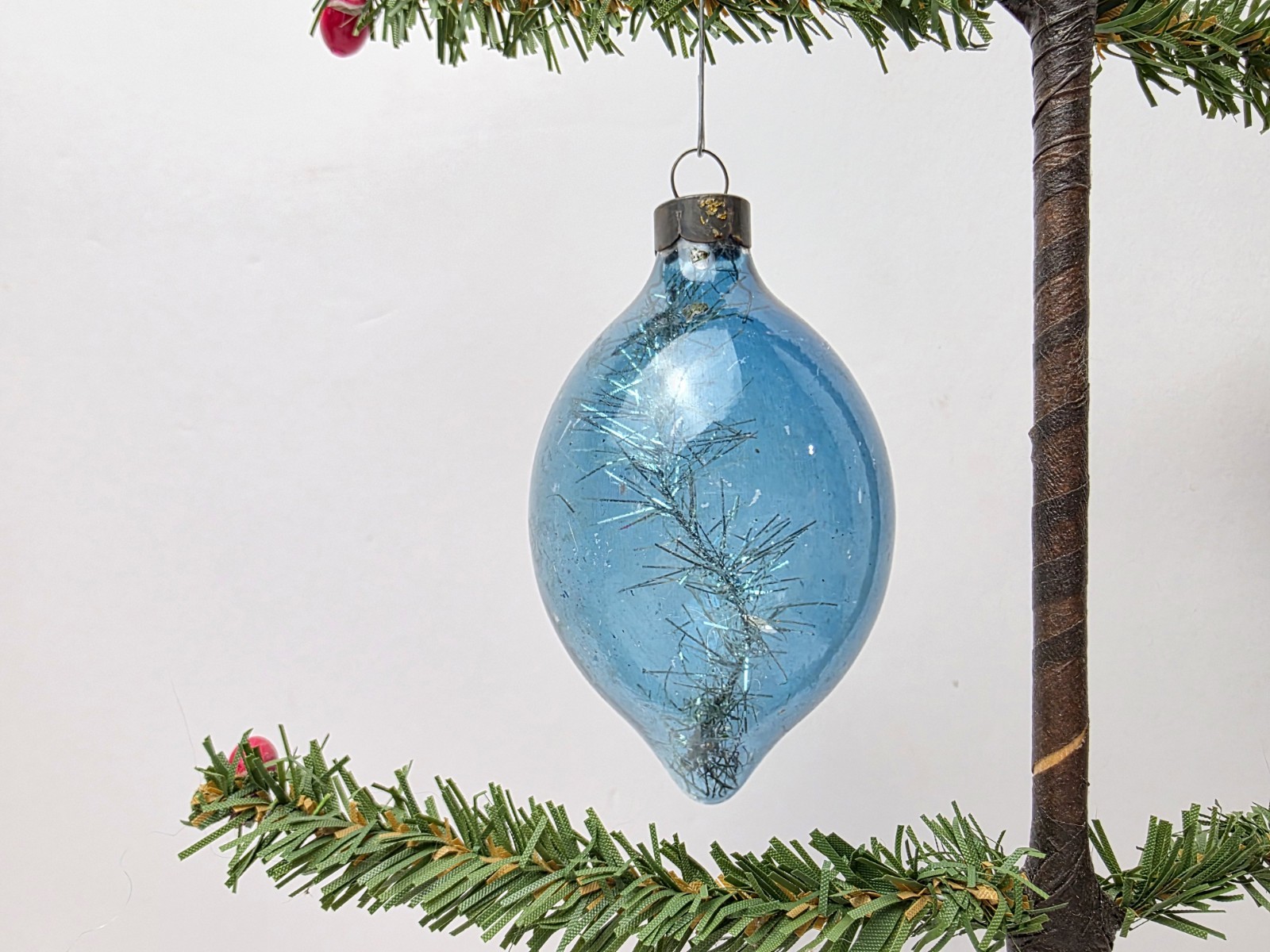 Vintage glass Christmas ornament with tinsel strand inside blue