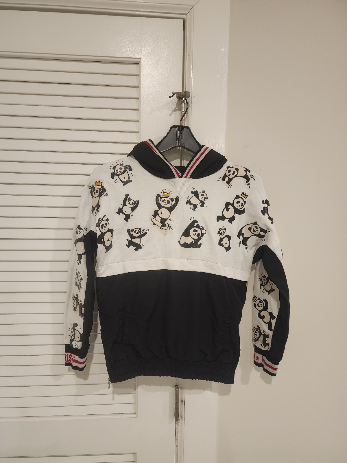 Stylish hoodie featuring playful panda prints. Black and white color scheme with