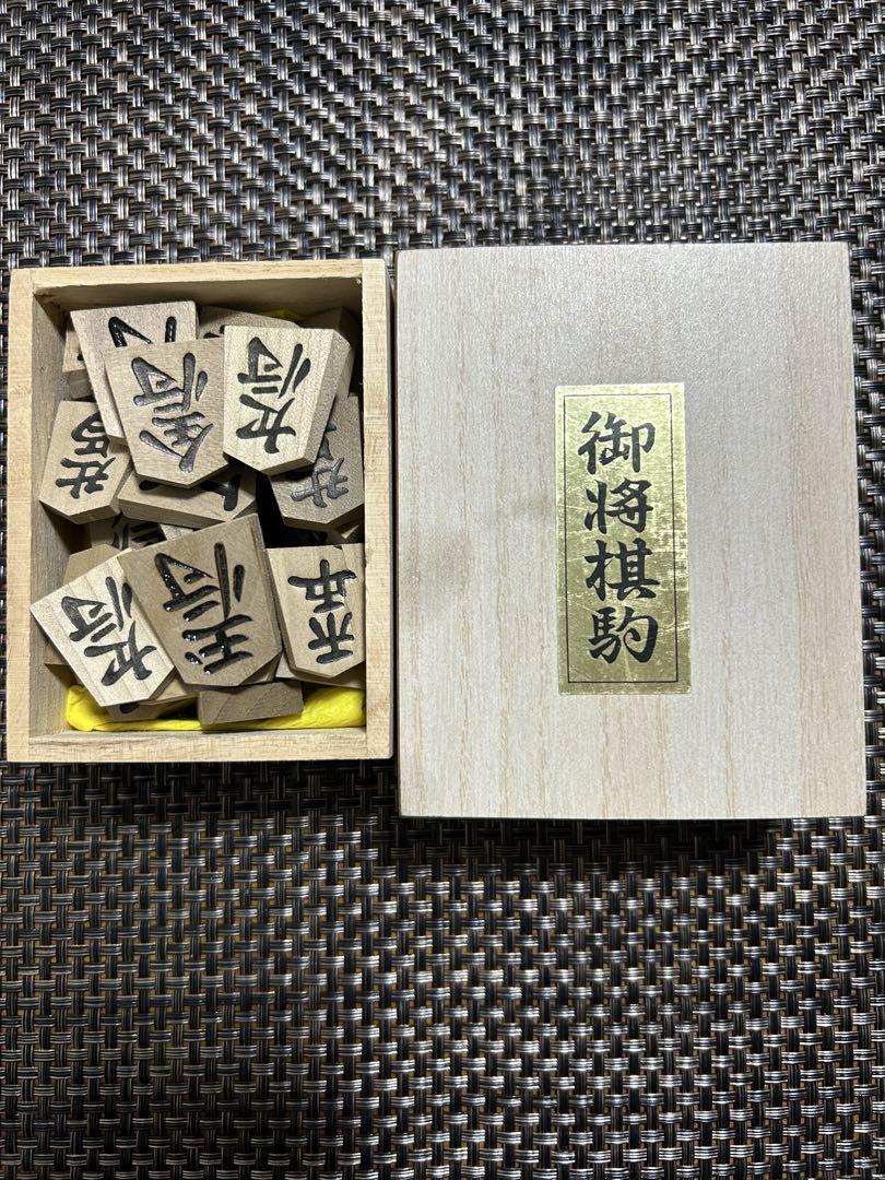 Shogi piece set with wooden storage box.