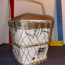 Ceramic dish with unique symbols enclosed in wire mesh basket