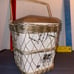 Ceramic dish with unique symbols enclosed in wire mesh basket