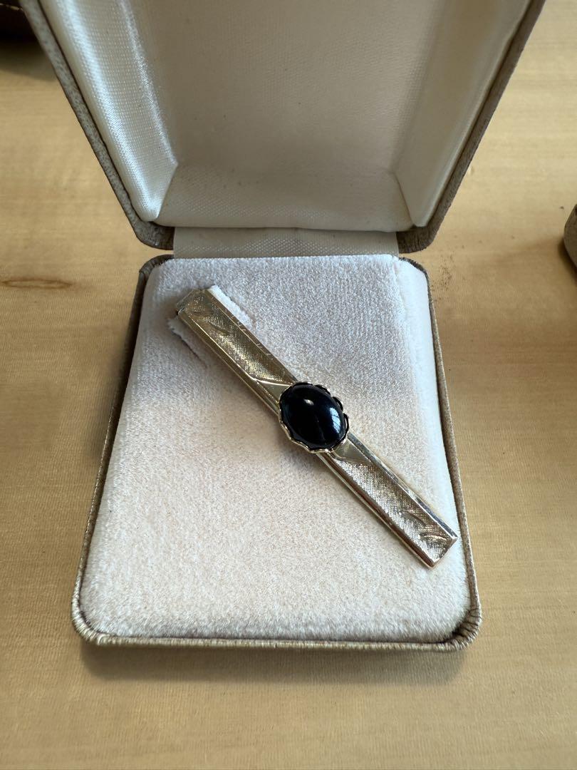 Tie pin with a black stone.